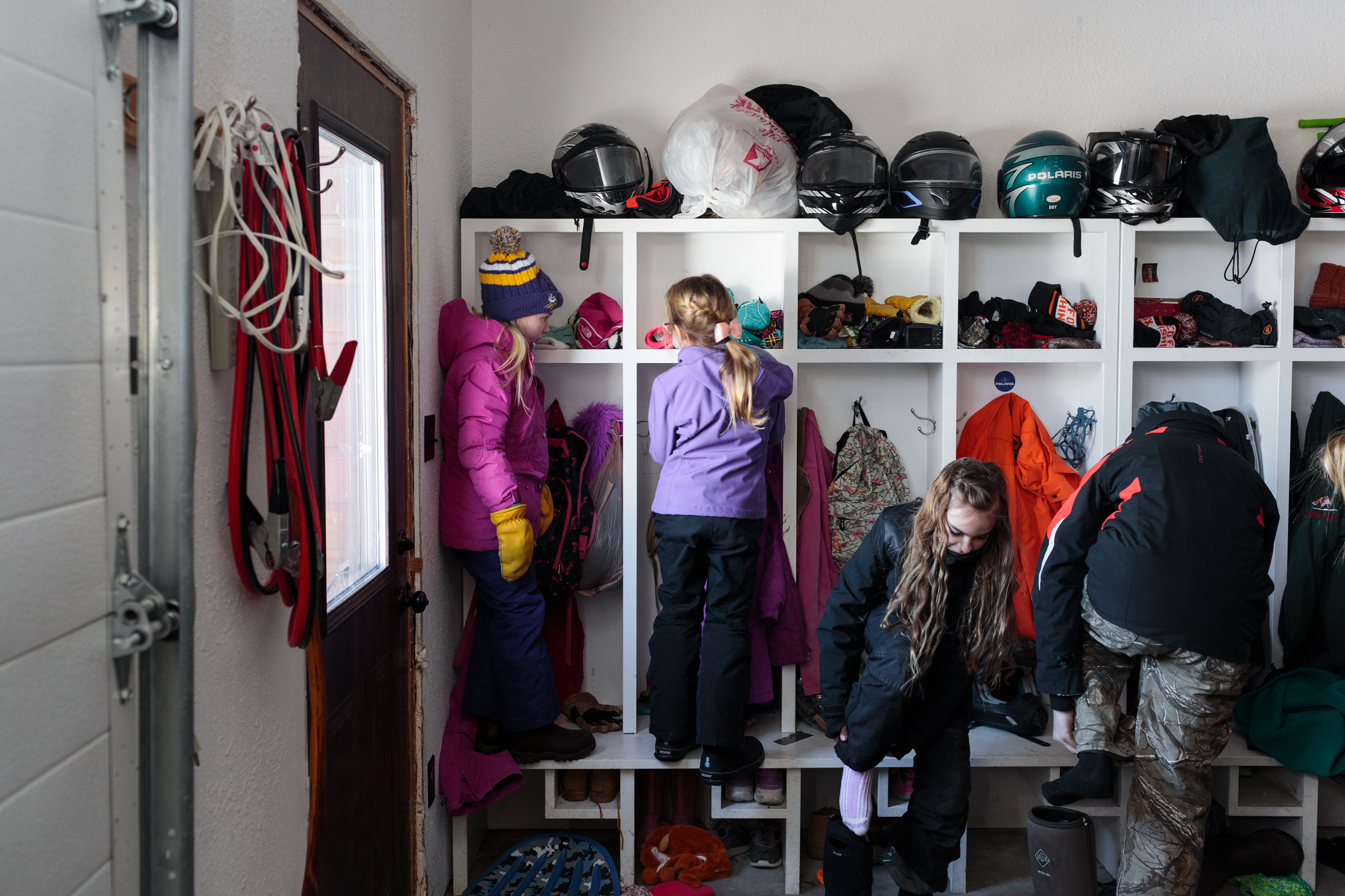 The Goulet family dresses in warm winter clothes before heading outside to play. The Goulet family has eight children, and operate the Angle Outpost Resort in Angle Inlet, offering lodges and outdoor activities such as ice fishing and hunting. They all have attended or are attending the Angle Inlet School. (Sarah Blesener for TIME)