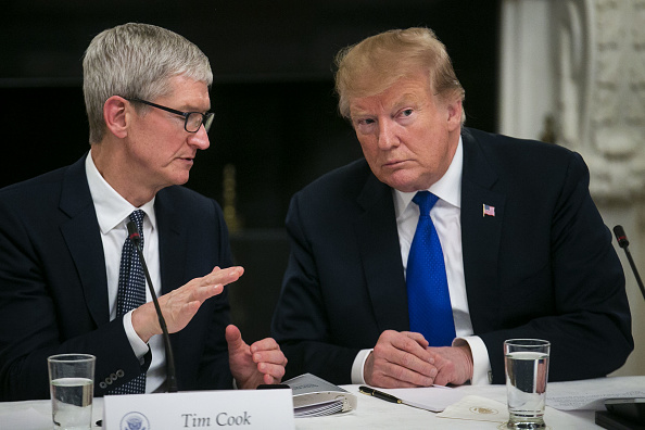 Tim Cook, chief executive officer of Apple Inc., speaks with U.S. President Donald Trump during an American Workforce Policy Advisory board meeting in the State Dining Room of the White House in Washington, D.C., U.S., on Wednesday, March 6, 2019.