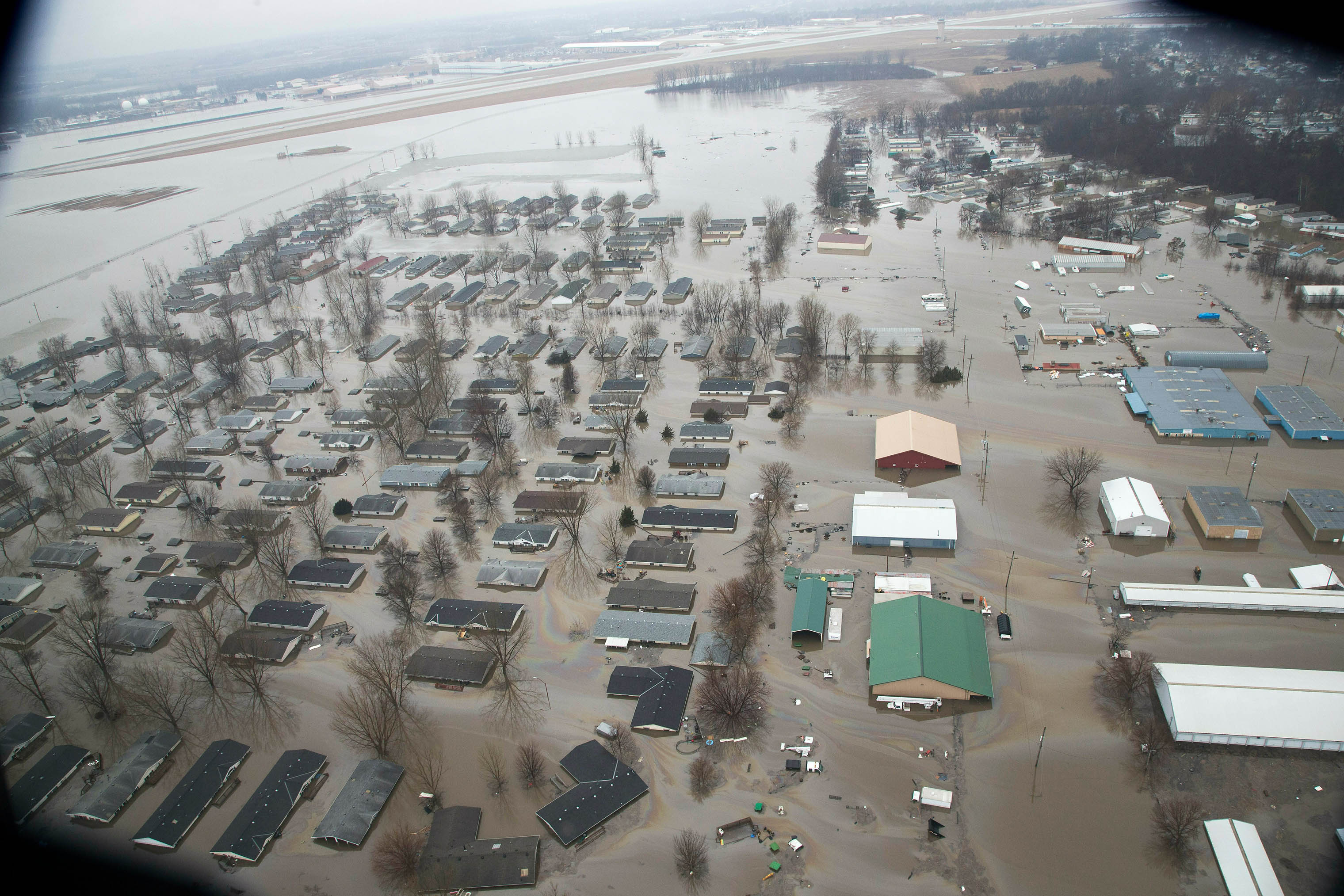 A neighborhood in Bellevue, Nebraska, is flooded by waters from the Missouri River, seen here with the Offutt Air Force Base runway. (Nati Harnik—AP/Shutterstock)