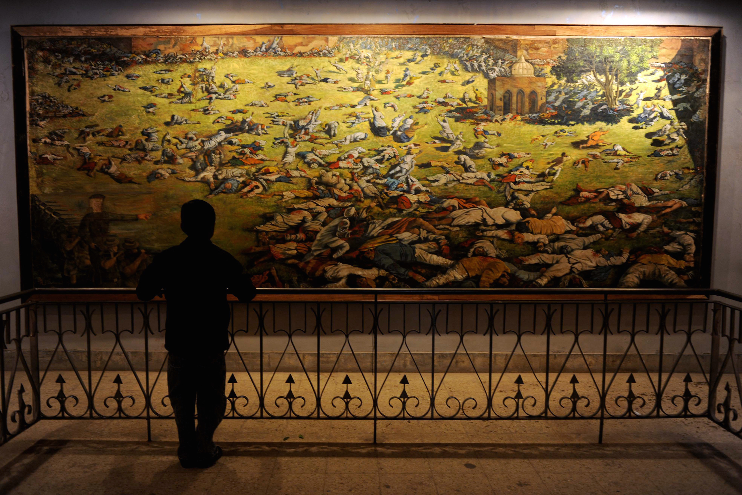 A young visitor looks at a painting depicting the Amritsar Massare at Jallianwala Bagh in Amritsar on Feb. 4, 2010. (Narinder Nanu—AFP/Getty Images)