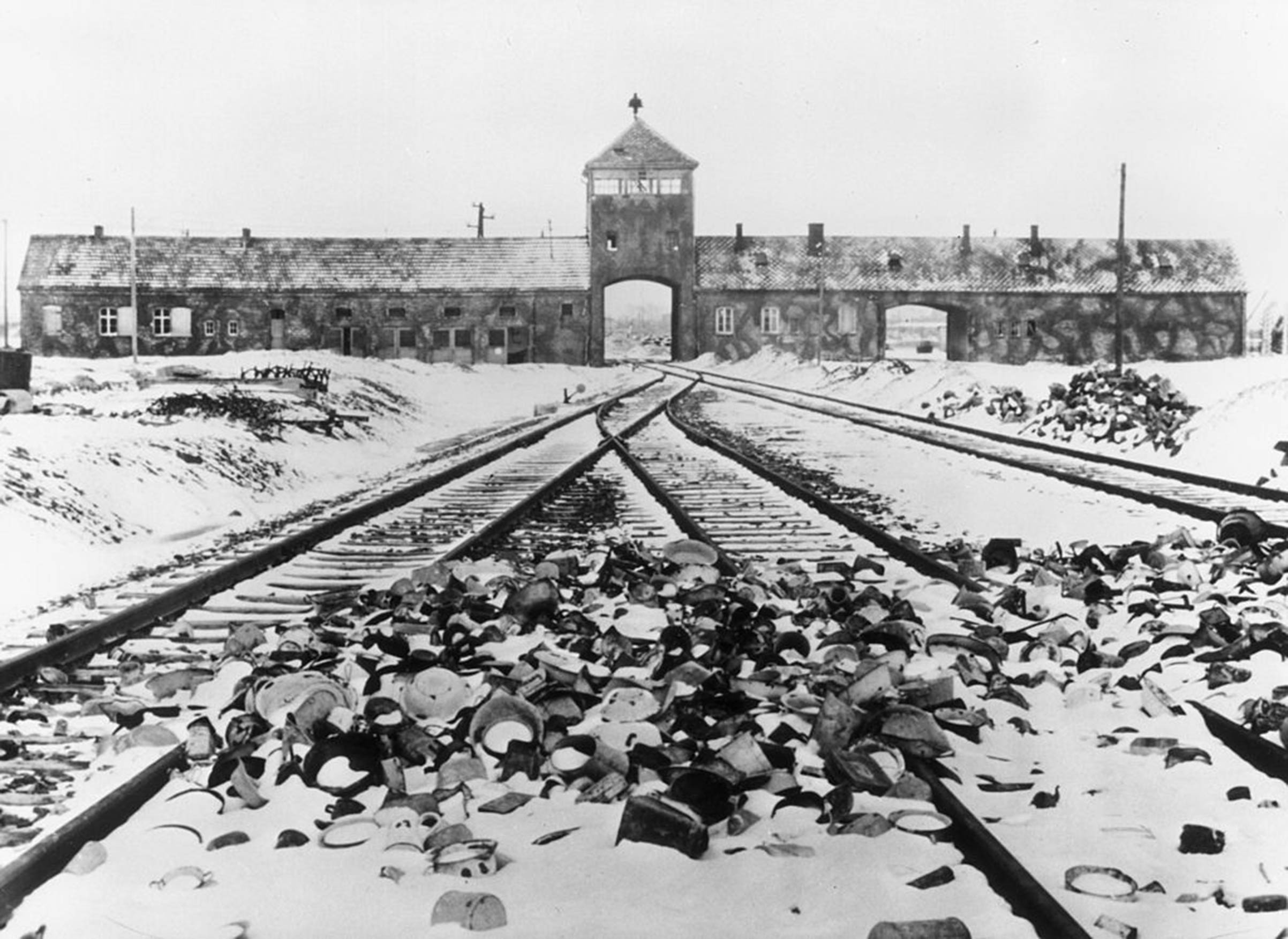 Snow-covered personal effects of those deported to the Auschwitz concentration camp in Poland litter the train tracks leading to the camp's entrance, circa 1945. (Hulton Archive—Getty Images)