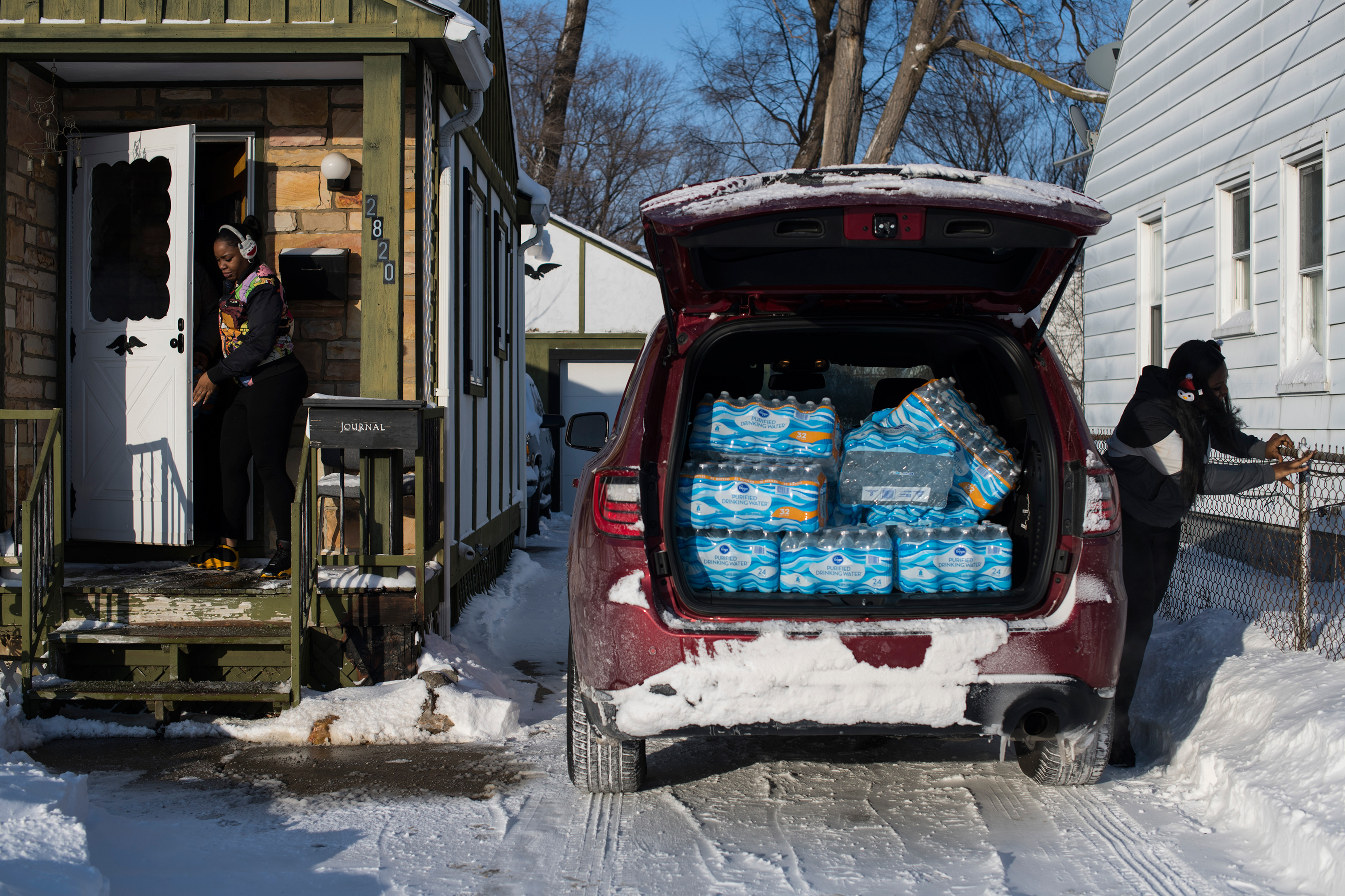 Hawk and a friend deliver cases of water, which she bought, to Flint residents in January. (Brittany Greeson for TIME)