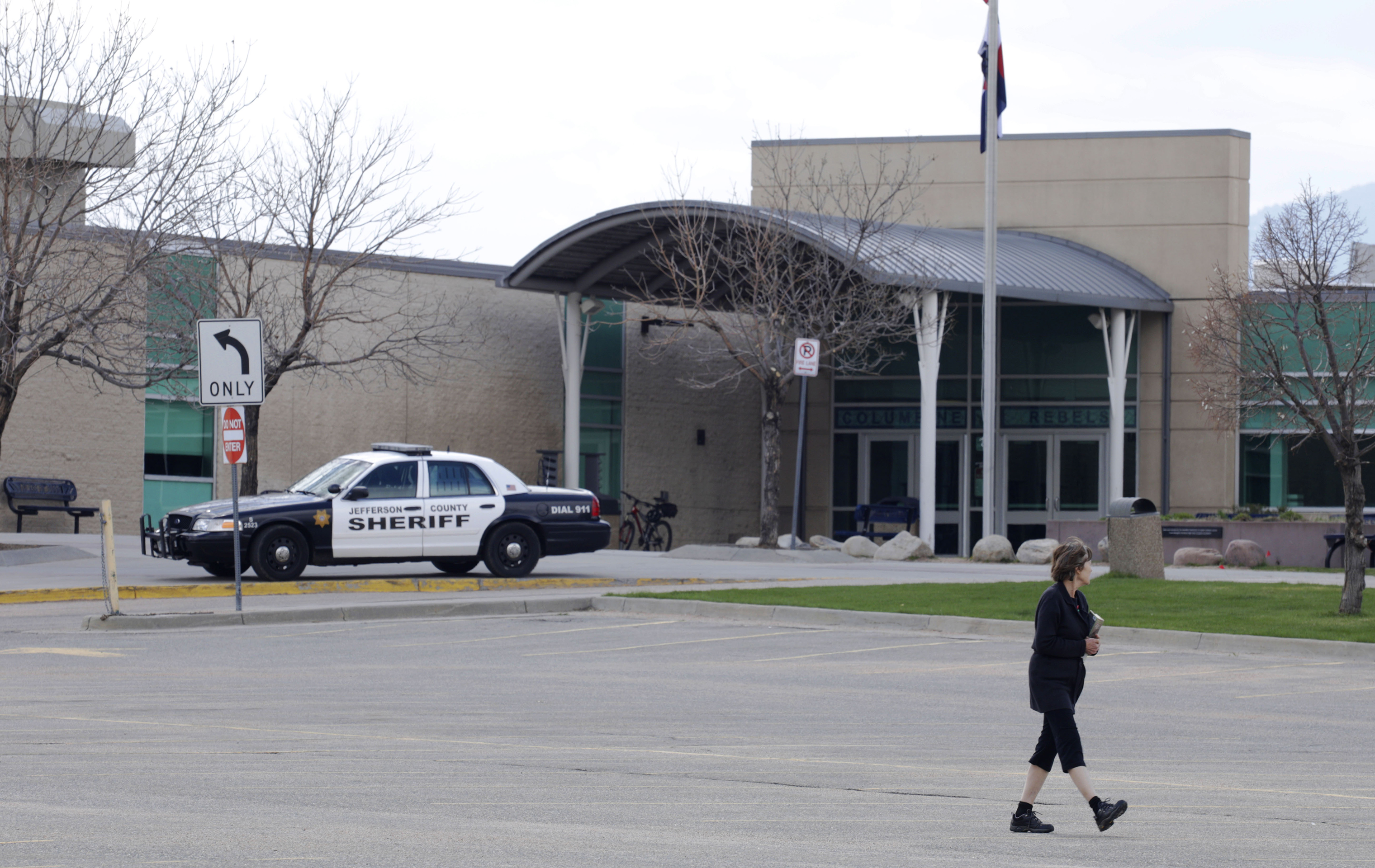 A woman walks across an empty parking lot a Columbine High School, Wednesday, April 17, 2019, in Littleton, Colorado, where two student killed 12 classmates and a teacher in 1999. (Joe Mahoney—AP)