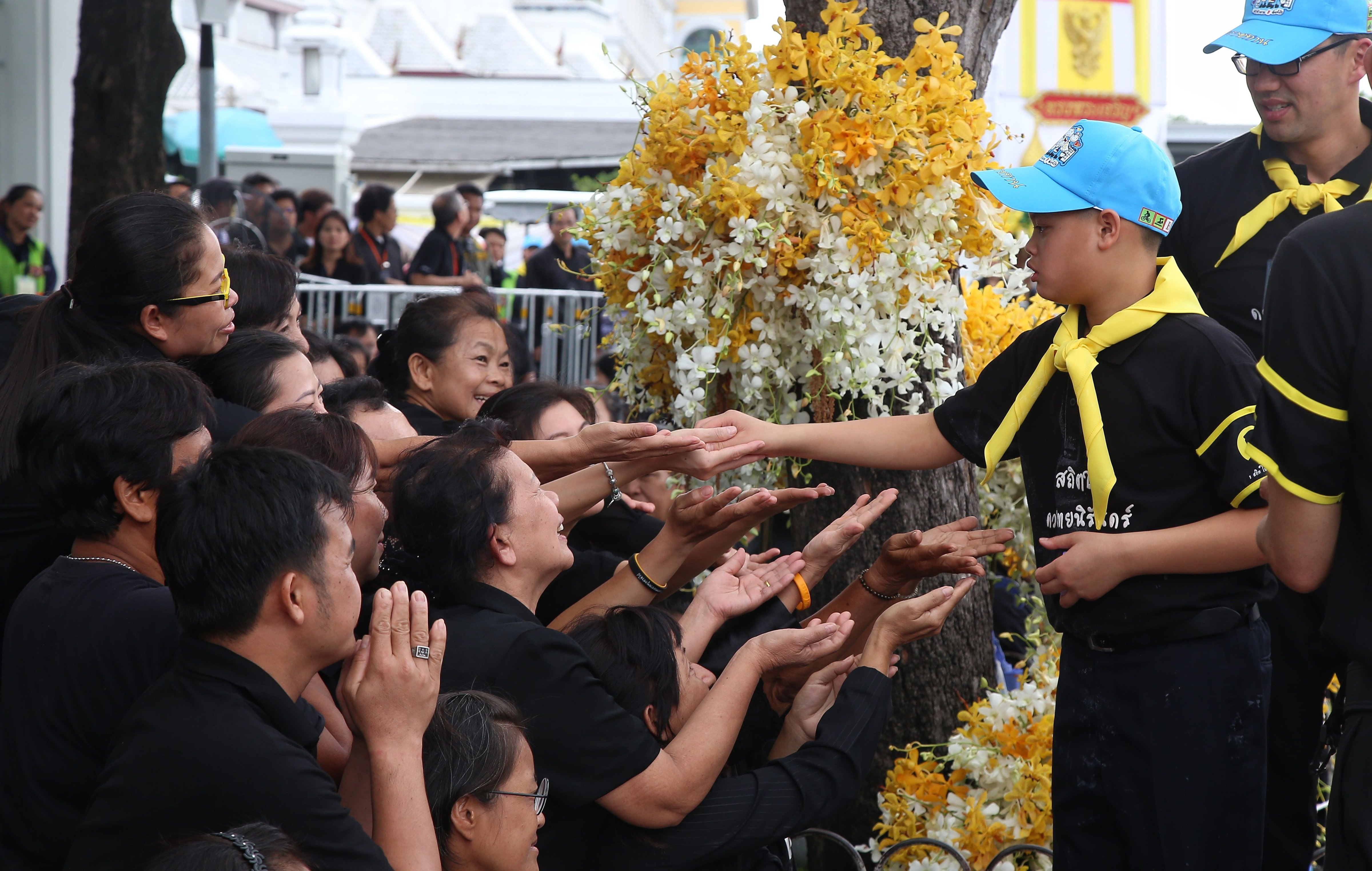 This picture by Thailand's Dailynews shows Prince Dipangkorn Rasmijoti (2nd R), 12, greeting well-wishers in Bangkok on October 25, 2017, near the site of where his grandfather, the late Thai King Bhumibol Adulyadej, will be cremated on October 26. (AFP Contributor—FP/Getty Images)