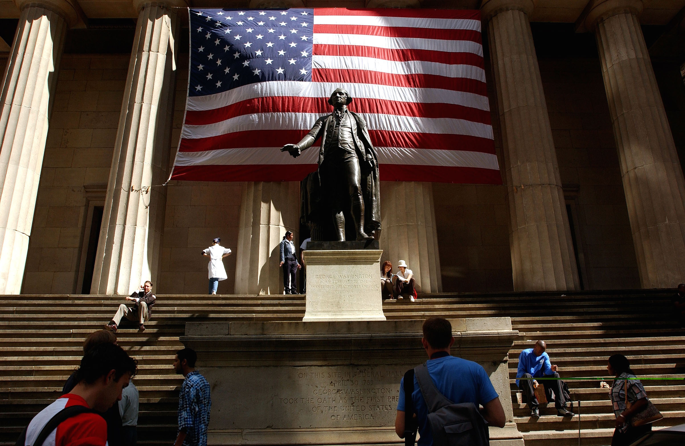 Pedestrians walk around the George Washington statue in front of Federal Hall Sept. 5, 2002 in New York City. (Spencer Platt—Getty Images)
