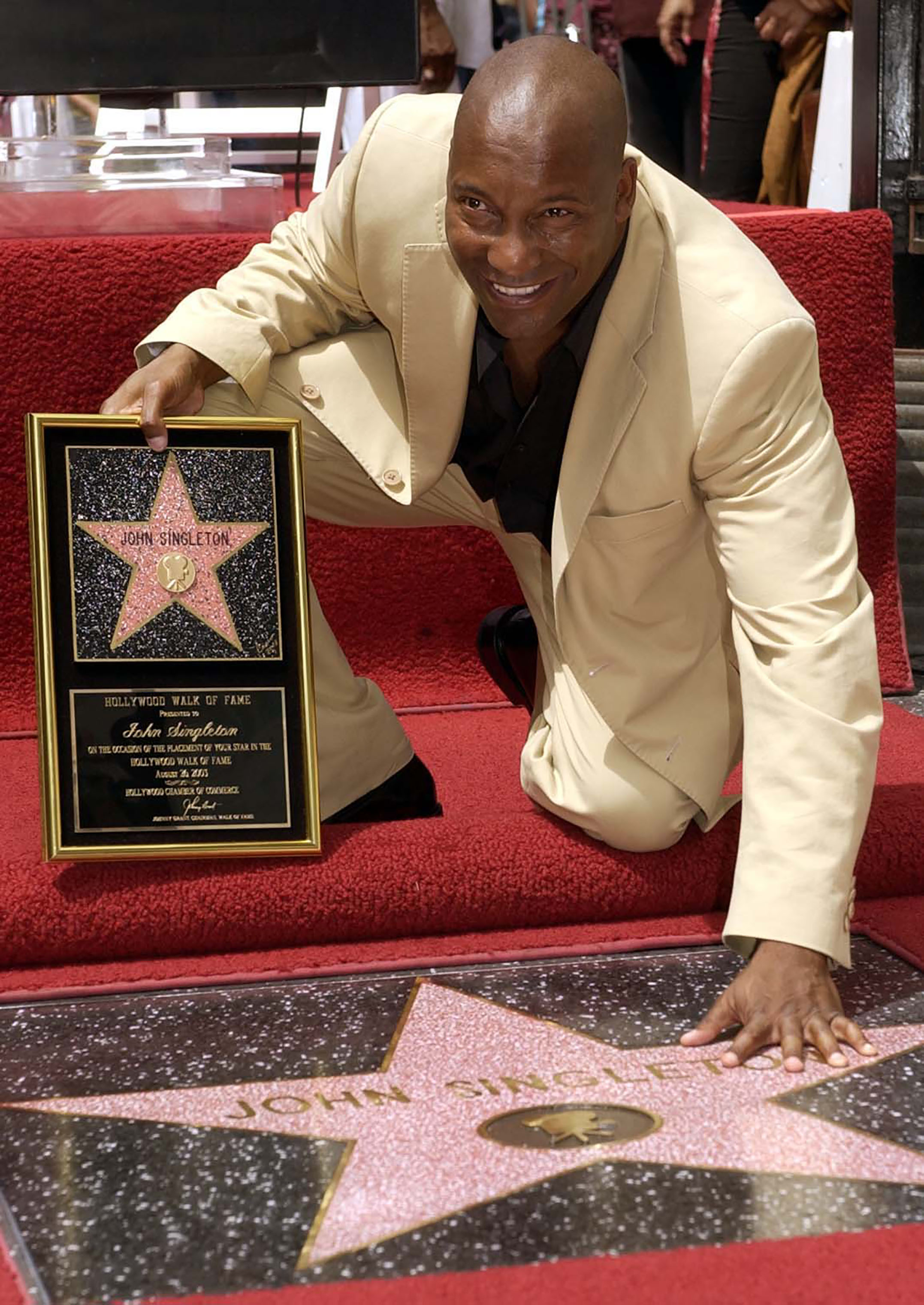 Director John Singleton touches his new star on the Hollywood Walk of Fame in Los Angeles, Tuesday, Aug. 26, 2003. (Nick Ut—AP)