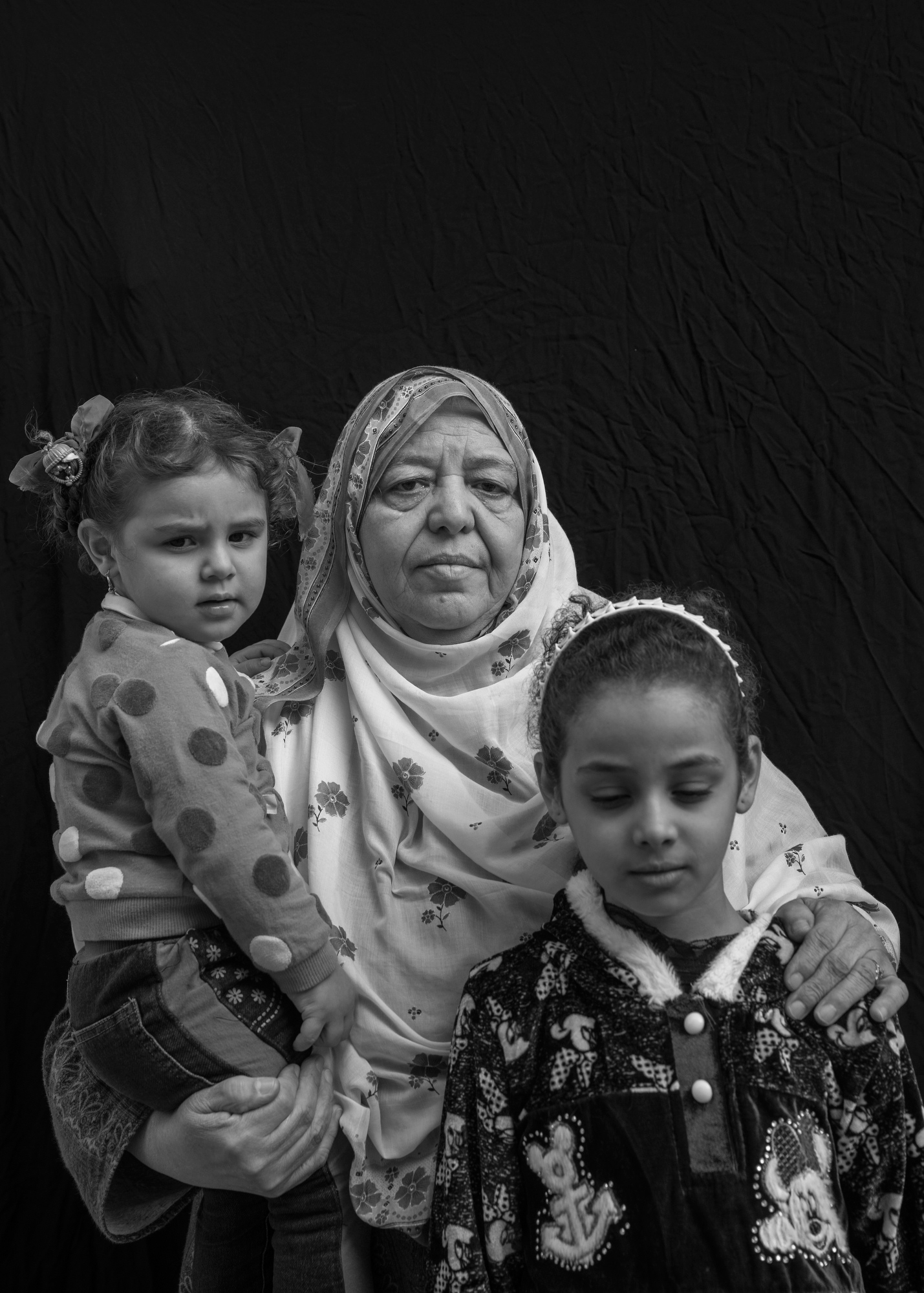Hawla Mahdi Salah, 67, poses for a portrait with her granddaughters Safae Khalid Adnan, 2, and Hawla Khalid Adnan, 9, in Mosul, Iraq. On June 26, 2017, an airstrike destroyed their home while they were inside. Salah lost nine family members in the blast, including two sons and three grandchildren, leaving her to care for Safae and Hawla who were orphaned, along with six other grandchildren. “Only Allah knows if the Old City will be rebuilt," she says. (Victor J. Blue)