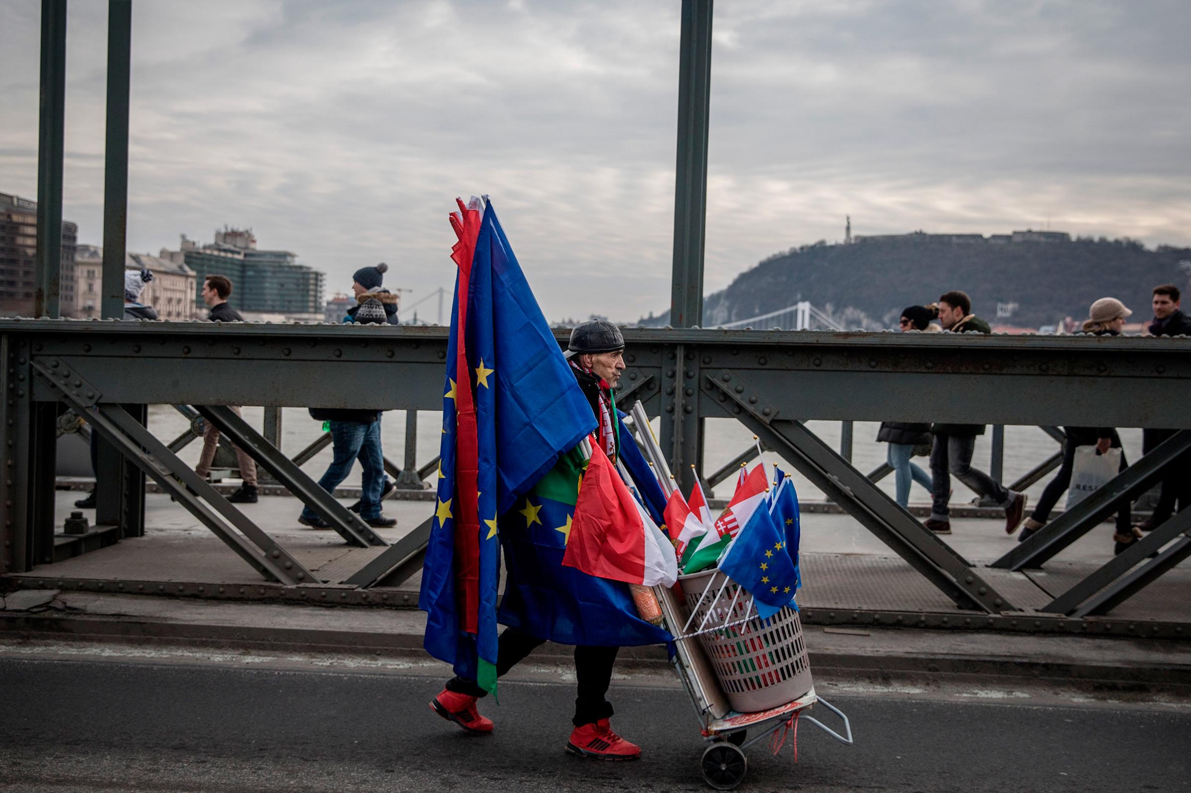 A man sells both Hungarian and E.U. flags in Budapest at a January protest against Orban’s government