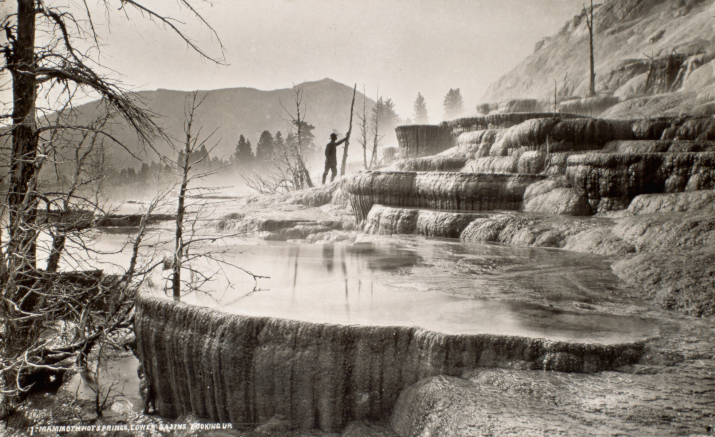 A man stands at the base of Mammoth Hot Springs in what is now Yellowstone National Park, Wyoming, ca. 1870. (Historical/Corbis/Getty Images)