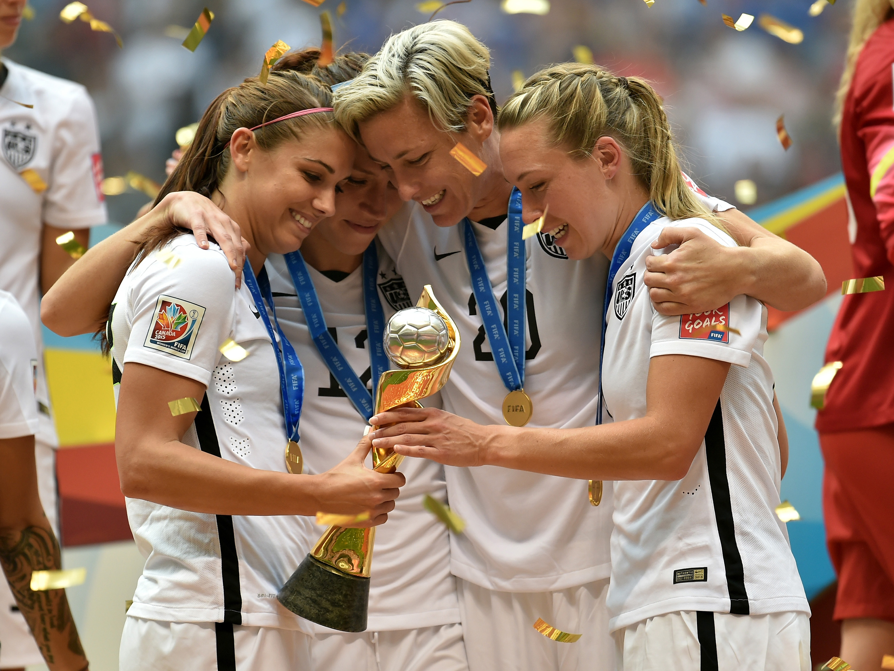 Alex Morgan #13, Lauren Holiday #12, Abby Wambach #20 and Whitney Engen #6 of the United States of America hold the World Cup Trophy after their 5-2 win over Japan in the FIFA Women's World Cup Canada 2015 Final at BC Place Stadium on July 5, 2015 in Vancouver, Canada. (Rich Lam—Getty Images)