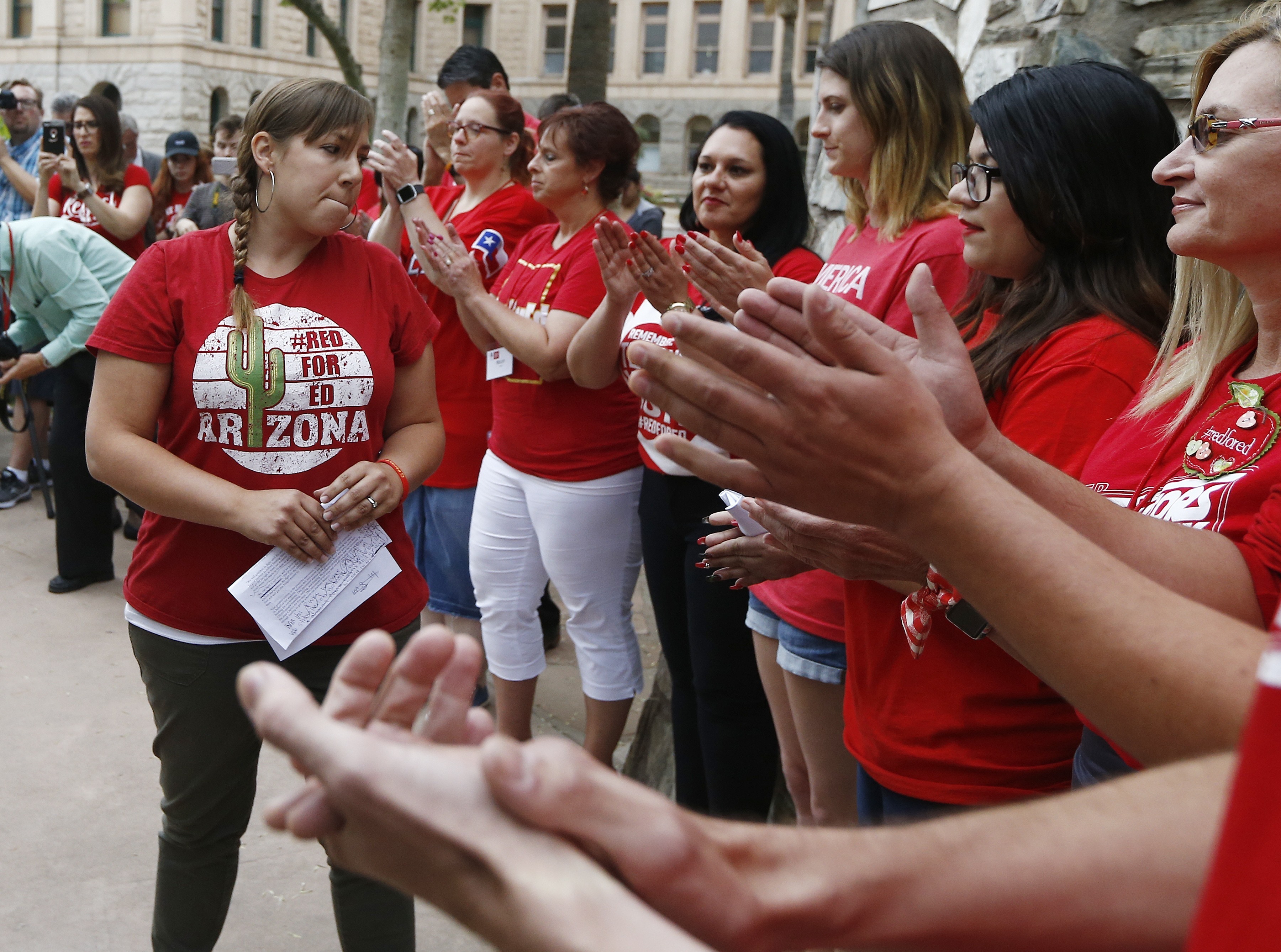 Phoenix teacher Rebecca Garelli, left, an Arizona Educators United member, is applauded after her announcement from protest organizers that teachers intend to go back to work as the statewide teachers strike enters a fourth day at the Arizona Capitol on May 1, 2018, in Phoenix. (Ross D. Franklin/AP)
