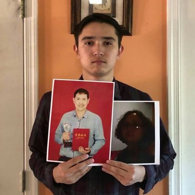 Uighur Student Arfat Erkin With Pictures of His Detained Parents