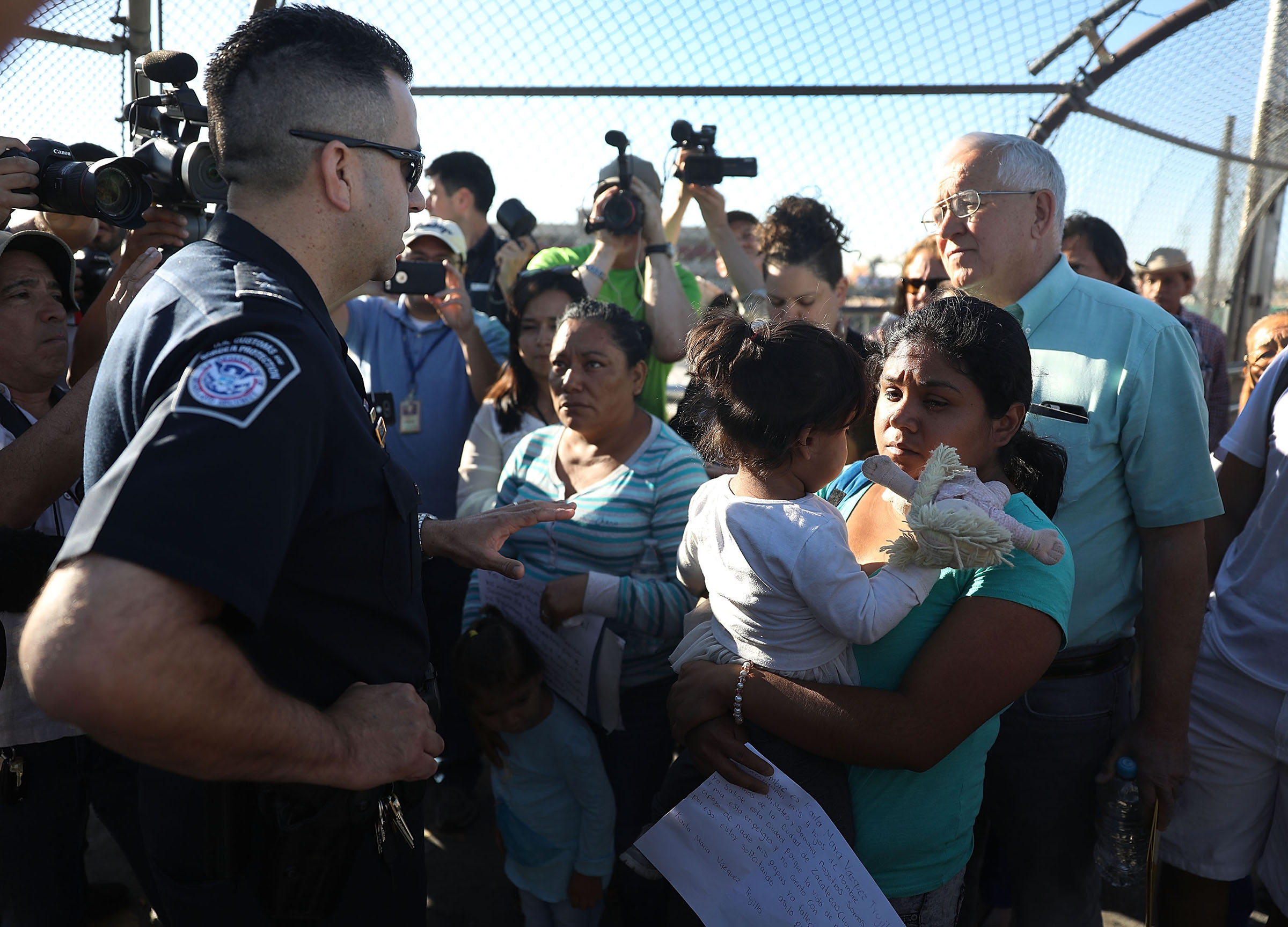 A U.S. Border Patrol agent informs Angelica and Karla (who didn't want their last names used),  that they will have to wait at the top of the Paso Del Norte Port of Entry, where the U.S. and Mexico border meet on June 20, 2018 in El Paso, Texas. (Joe Raedle—Getty Images)