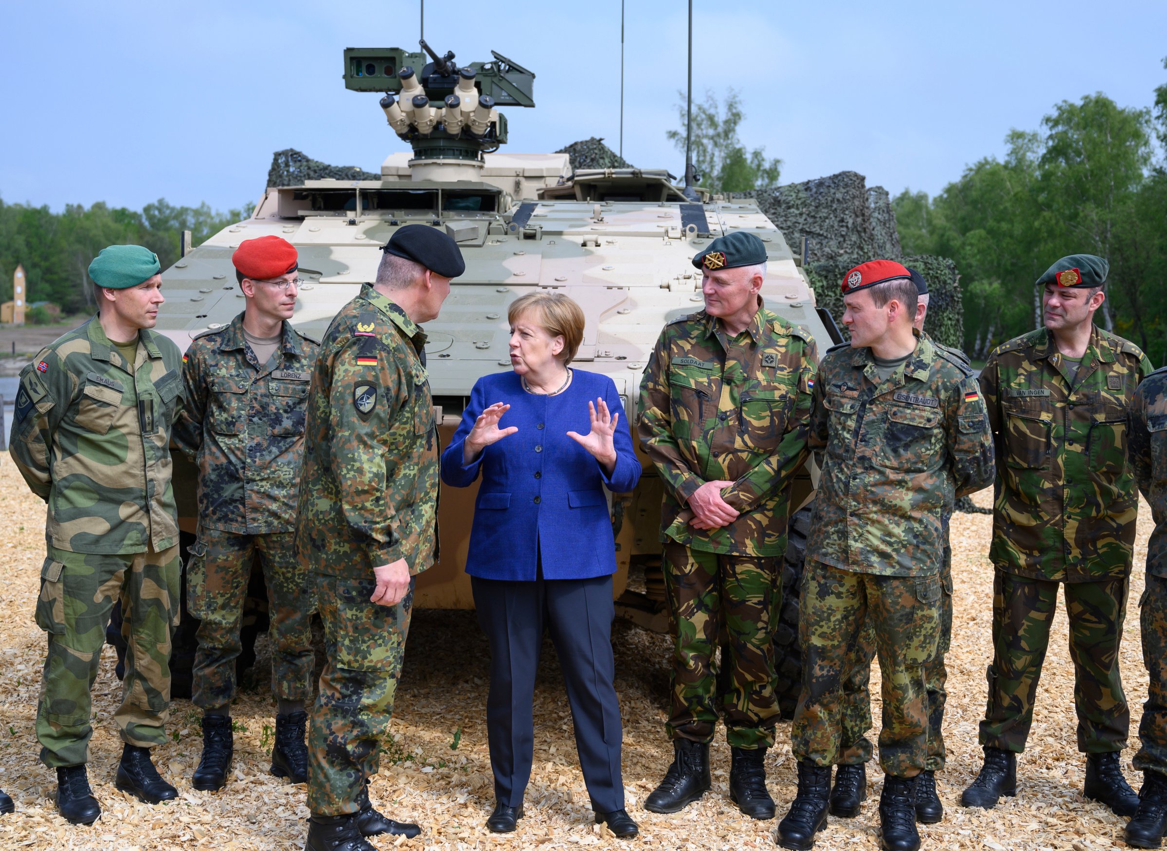Germany’s military is investigating what information three Chinese reporters collected while Chancellor Angela Merkel visited a NATO base.
