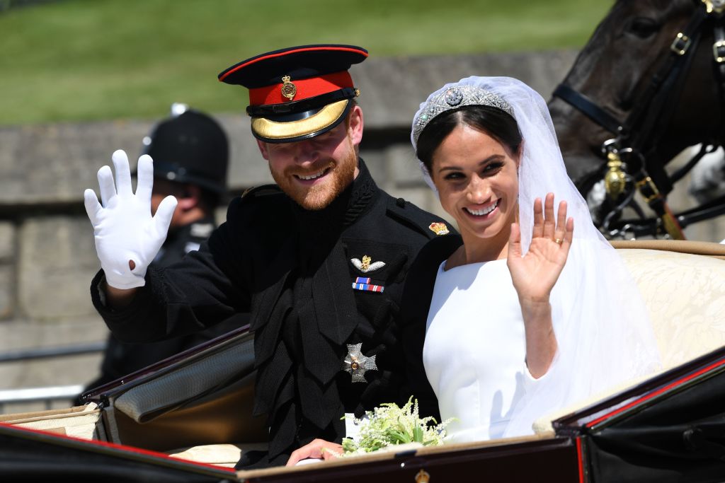 Britain's Prince Harry, Duke of Sussex and his wife Meghan, Duchess of Sussex wave from the Ascot Landau Carriage during their carriage procession on Castle Hill outside Windsor Castle in Windsor, on May 19, 2018 after their wedding ceremony. (PAUL ELLIS&mdash;AFP/Getty Images)