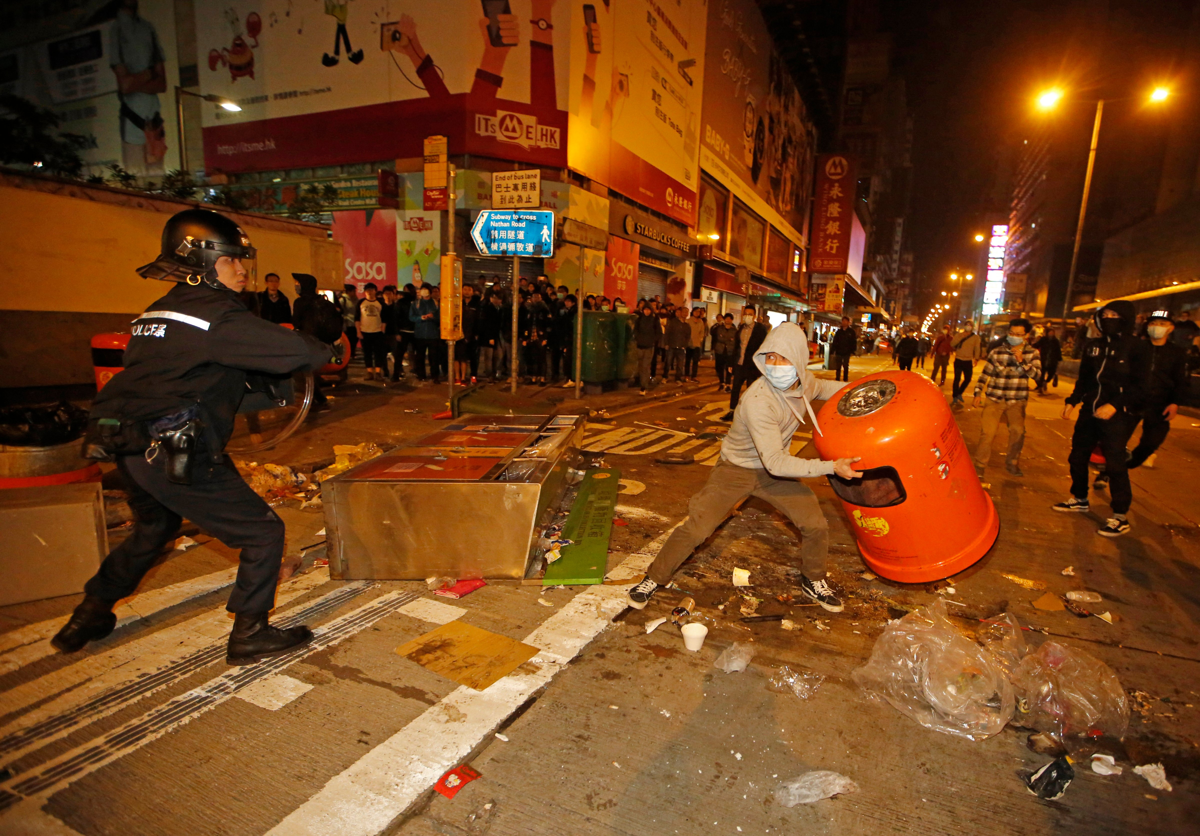 A rioter tries to throw a litter bin at police on a street in Mongkok district of Hong Kong, Feb. 9, 2016. (Kin Cheung&mdash;AP)