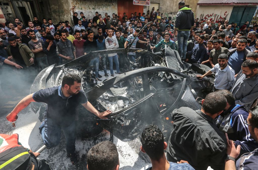 Palestinian emergency personnel try to put out the fire on a car belonging to Hamas member Hamad al-Khodori, in Gaza City on May 5, 2019, after it was hit by an Israeli airstrike. A Palestinian militant was killed in an Israeli retaliatory strike in the Gaza Strip, Gazan officials said, in response to rocket barrages fired from the enclave. (MAHMUD HAMS&mdash;AFP/Getty Images)