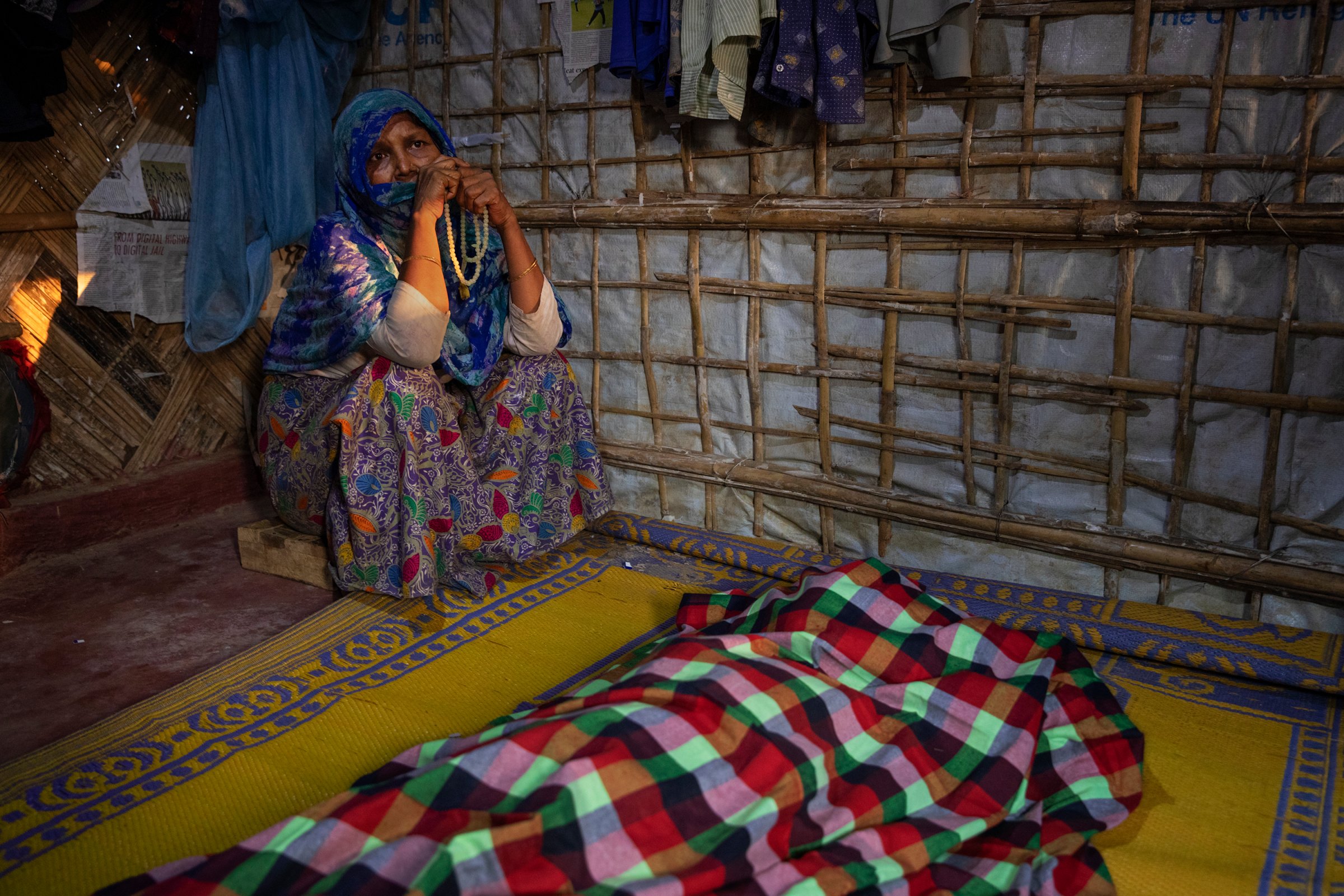 A woman grieves for Fatema Begum, 60, in the hut of the deceased.