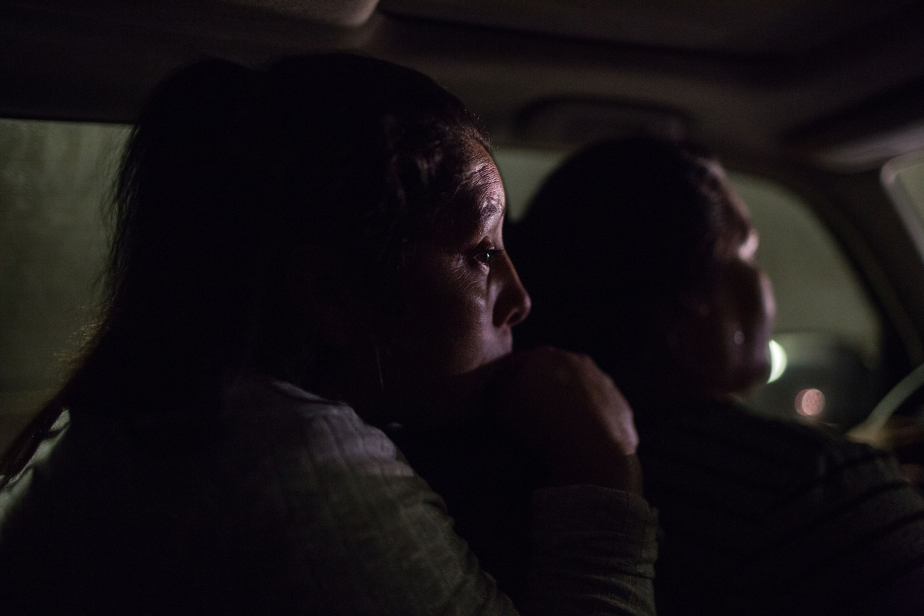 Maria, left, sits in the back of a car returning to suburban Washington, D.C., after visiting her brother, who also lives on the East Coast, on March 24. Castro often gets sad and misses her mother and her other children. “I still have a house in Honduras, it's the house my dad gave me; it’s not a real house, it's made of mud,” said Castro. “But it’s all I have there; if this does not work here, that’s where I will go back to.” (Federica Valabrega)