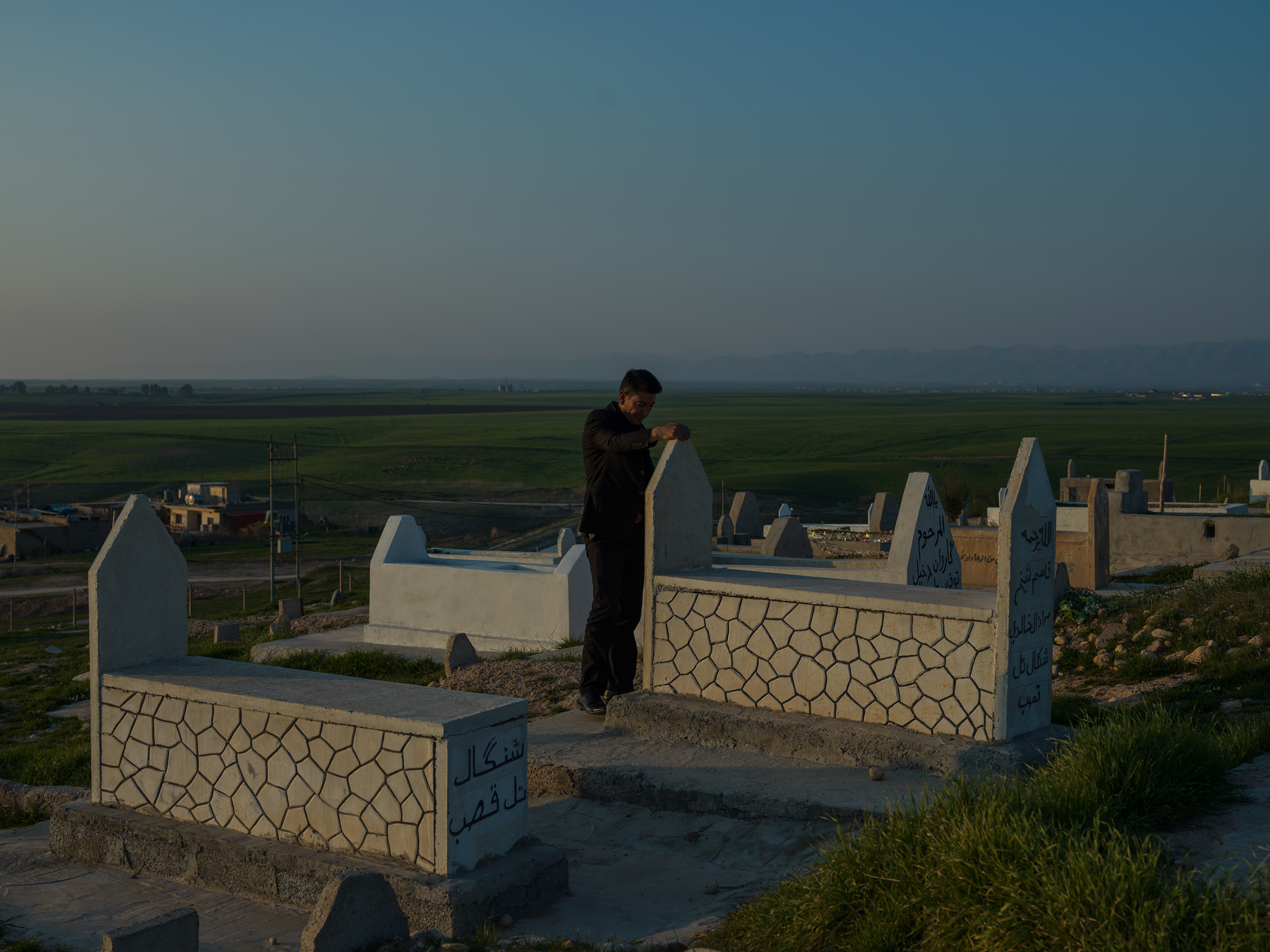 A man mourns at a Yezidi cemetery in Duhok, where many Yezidis killed by ISIS are buried, in February. (Newsha Tavakolian—Magnum Photos for TIME)