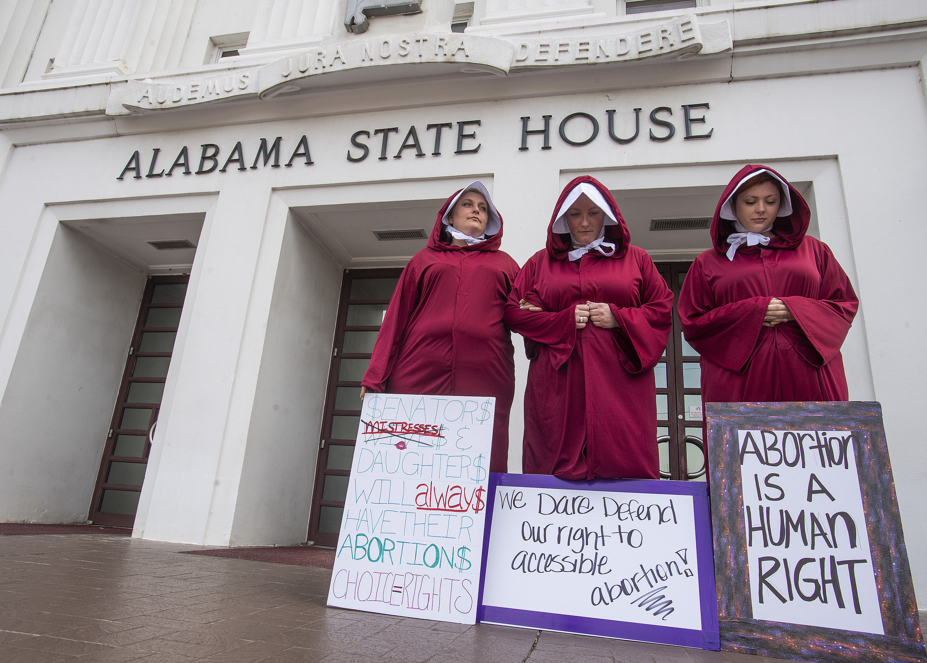 Bianca Cameron-Schwiesow, from left, Kari Crowe and Margeaux Hartline, dressed as handmaids, take part in a protest against HB314, the abortion ban bill, at the Alabama State House in Montgomery, Ala., on Wednesday April 17, 2019. (Mickey Welsh/The Montgomery Advertiser via AP) (Mickey Welsh—The Montgomery Advertiser/AP)