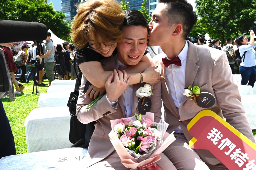 Shane Lin (C) is comforted by his partner Marc Yuan (R) and a friend during a wedding ceremony in Shinyi district in Taipei on May 24, 2019. (Sam Yeh—AFP/Getty Images)