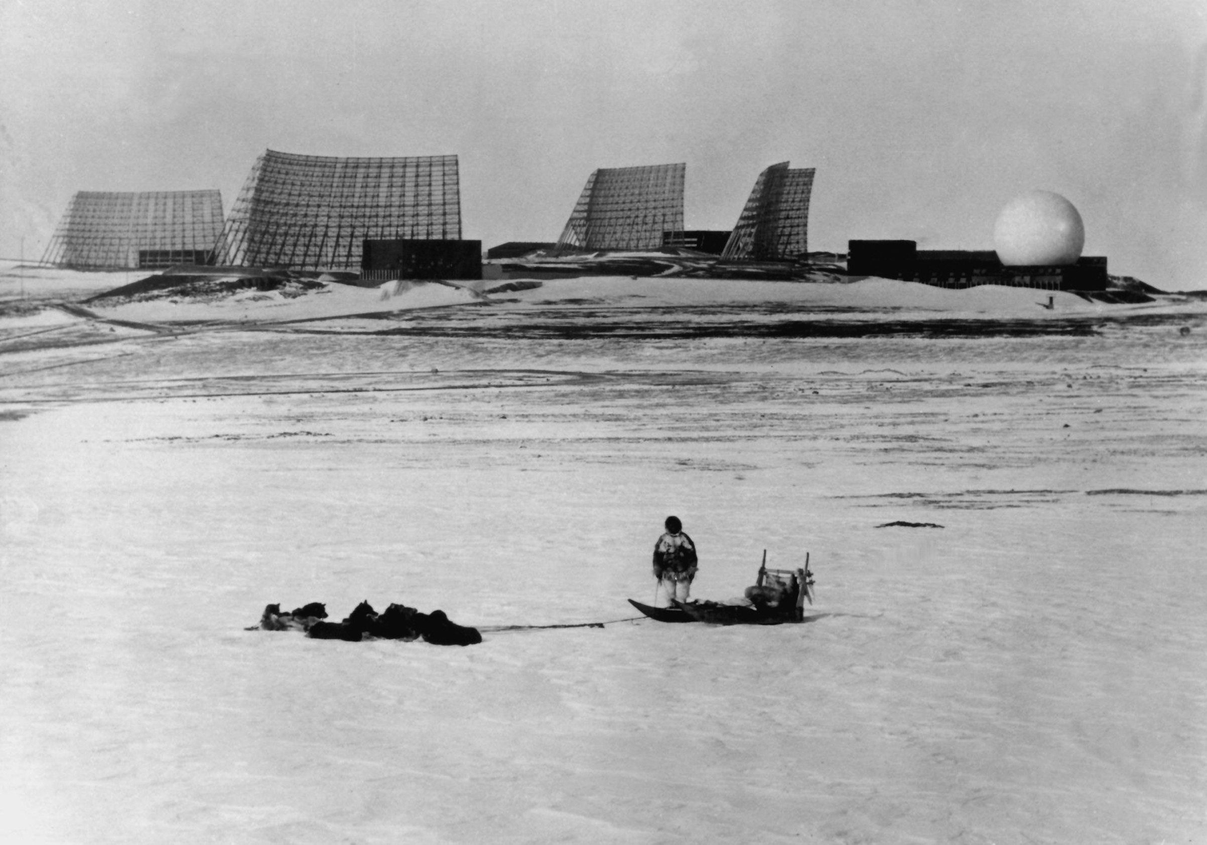 A Greenlander with his dog sleigh looks at the radars at Thule Air Base in Northern Greenland in 1966. (NF/AFP/Getty Images)