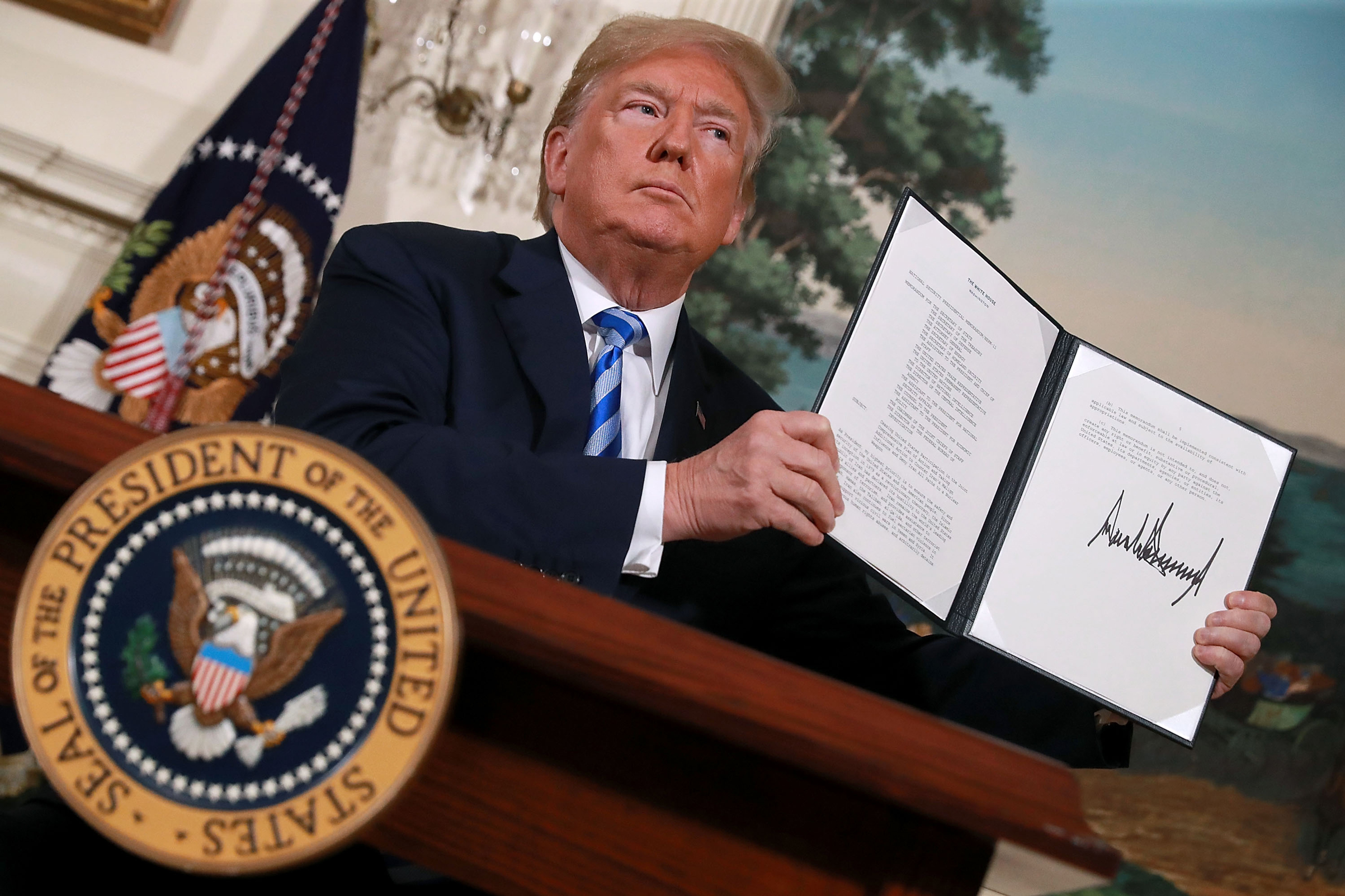 President Donald Trump holds up a memorandum that reinstates sanctions on Iran after he announced his decision to withdraw the United States from the 2015 Iran nuclear deal, on May 8, 2018, in Washington, D.C. (Chip Somodevilla/Getty Images)