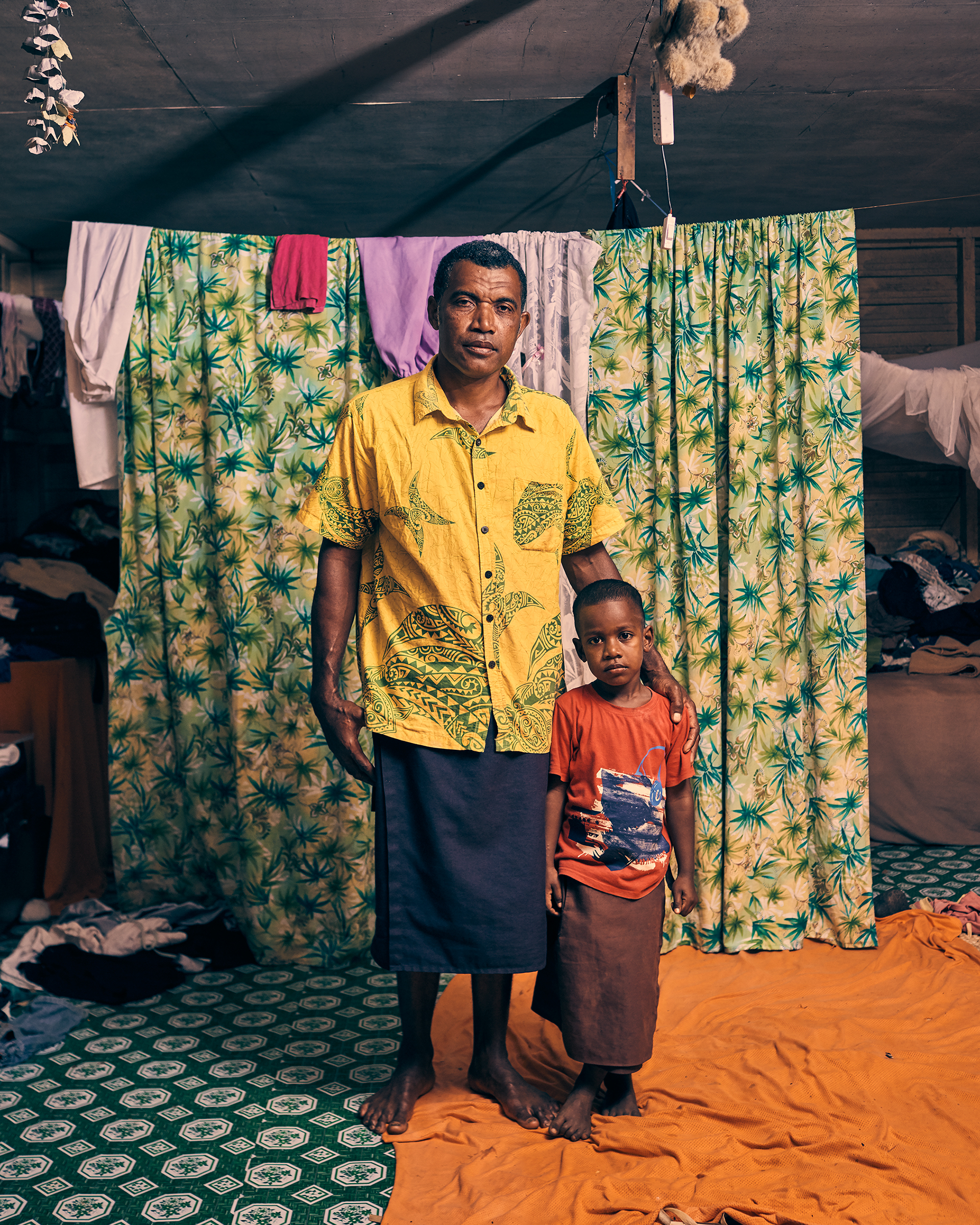 Penioni Soqovata and his son Josefa Mairara, photographed in their home in Vunidogoloa. The boy was the first baby born in the relocated village.