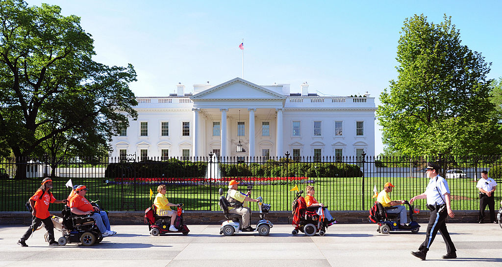 Members of ADAPT, a disability rights group pass the White House during a protest April 27, 2009 in Washington, DC. (KAREN BLEIER—AFP/Getty Images)