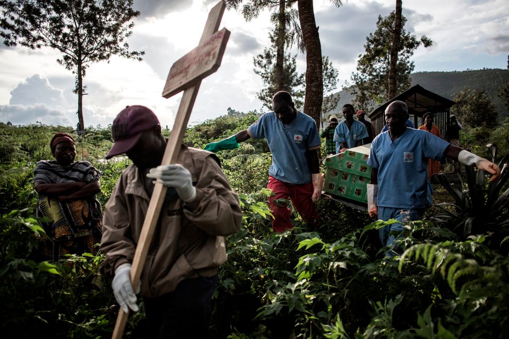 Health workers carry a coffin containing a victim of Ebola virus in Butembo, Democratic Republic of Congo, on May 16. (John Wessels—Getty Images)