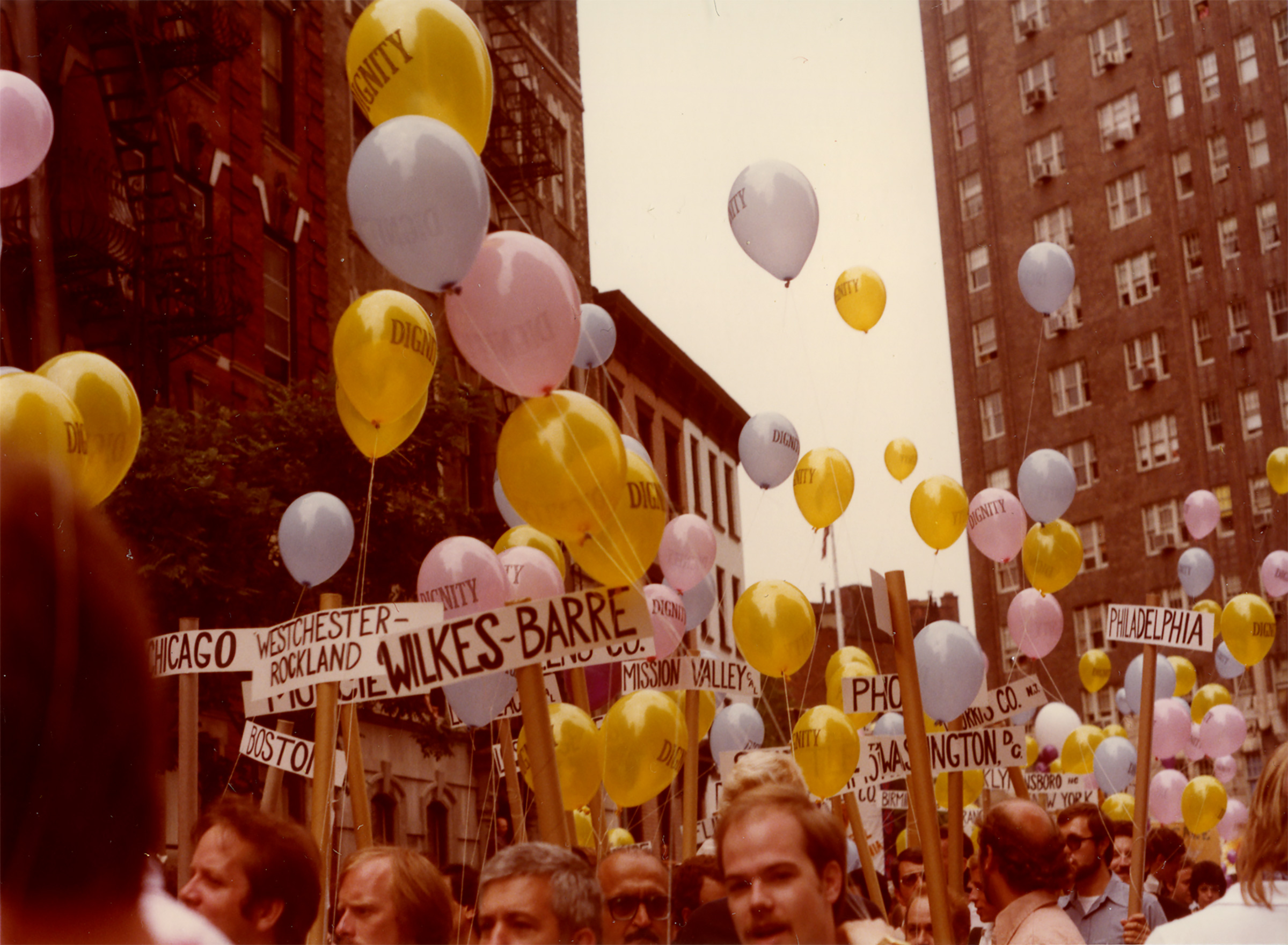 People march with balloons saying DIGNITY and picket signs that indicate place of origin, 1980 (Courtesy of the Estate of George Dudley and the Leslie-Lohman Museum)