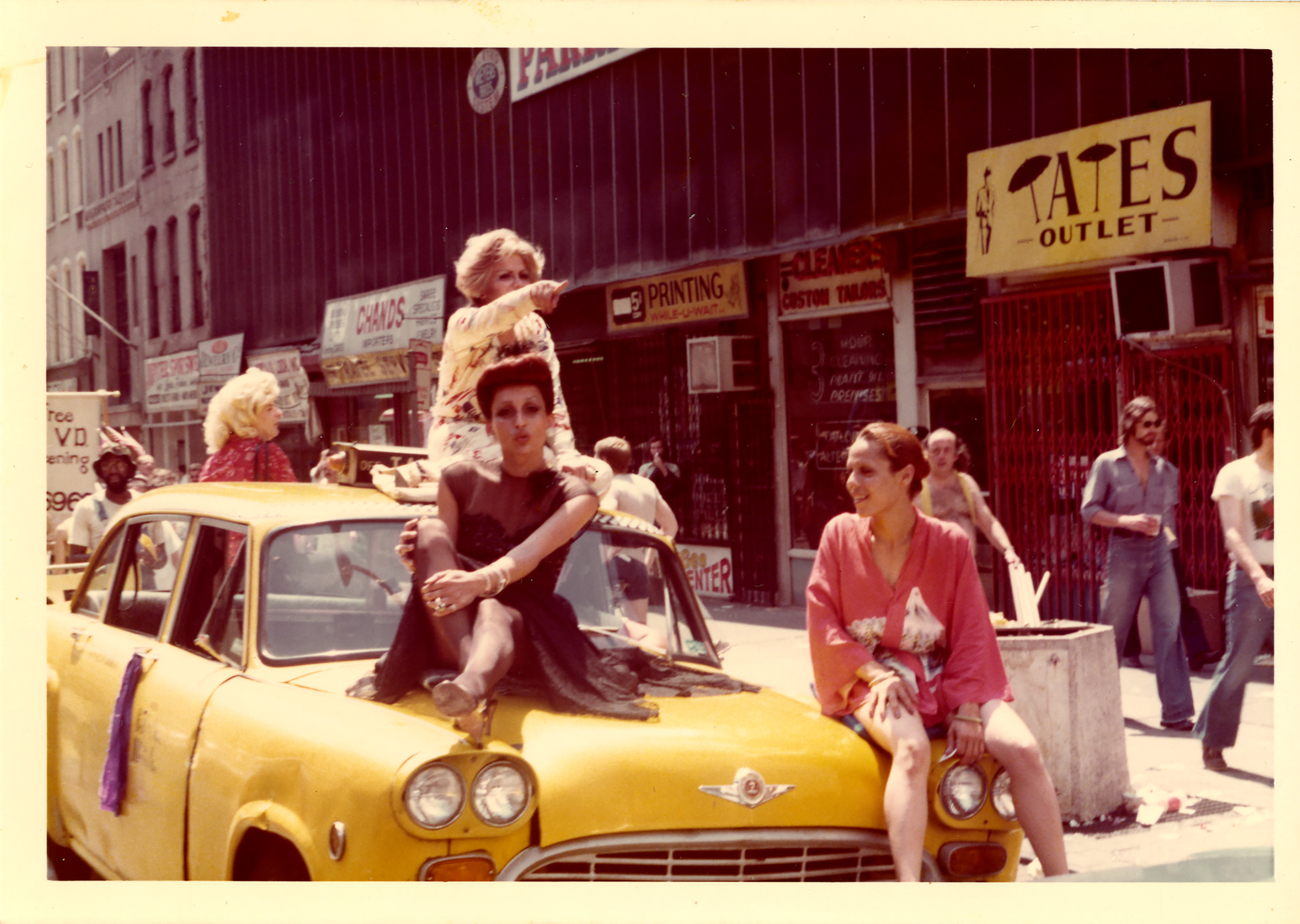 People perform on top of a yellow cab in 1976 (Courtesy of the Estate of George Dudley and the Leslie-Lohman Museum)