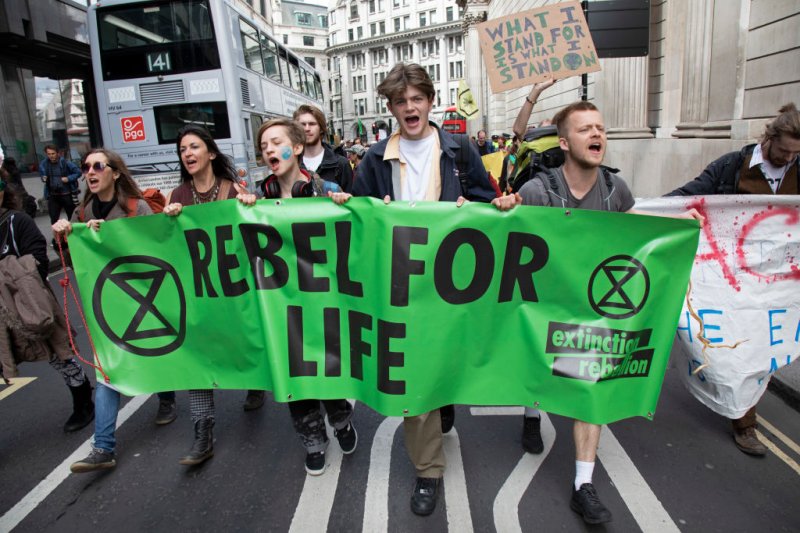 Climate change activists from the Extinction Rebellion group march up to block the street at Bank in the heart of the City of London financial district in protest that the government is not doing enough to avoid catastrophic climate change and to demand the government take radical action to save the planet, on 25th April 2019 in London, England, United Kingdom.