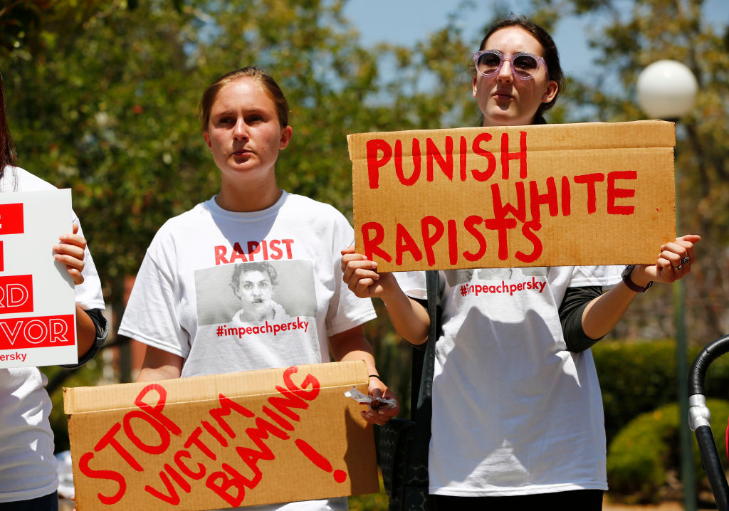 Zoe Gregozek and Hattie Dalzell, left to right, attend a protest calling for the impeachment of Santa Clara County Superior Court Judge Aaron Persky at the Old Courthouse in San Jose, California on Monday, August 1, 2016. Upset by the light jail sentence he gave former Stanford student Brock Turner. (Gary Reyes/Bay Area News Group – Getty Images)