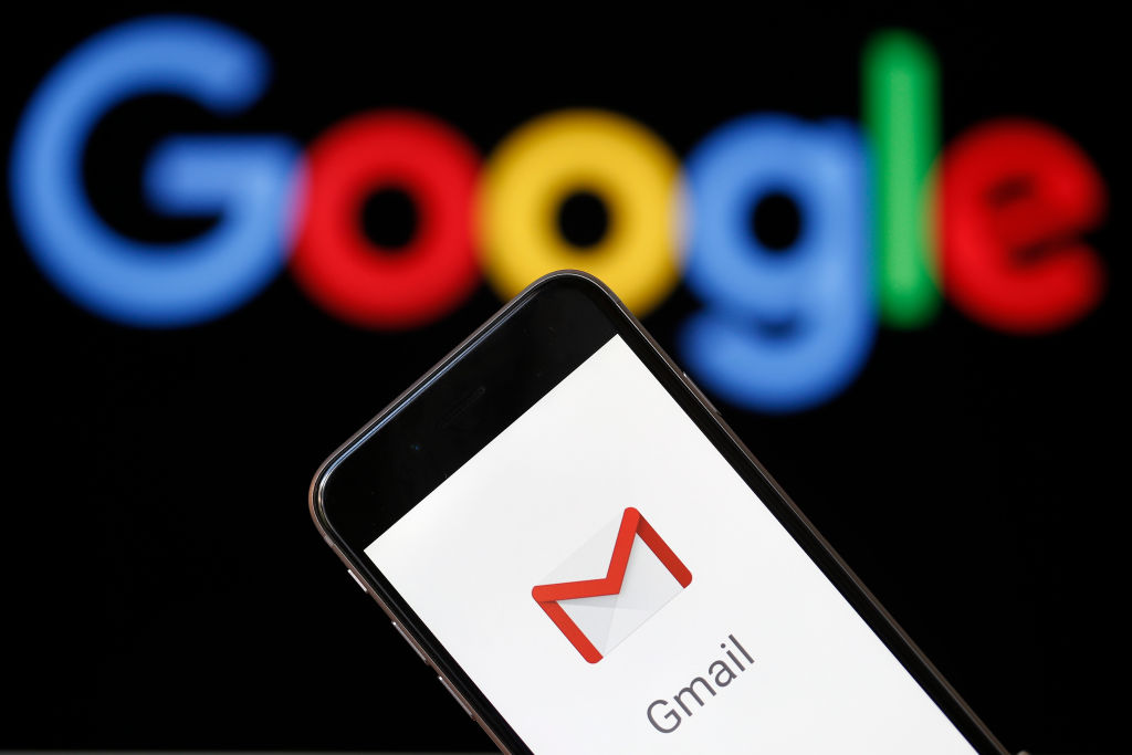 In this photo illustration, the logo of the Gmail app homepage is seen on the screen of an iPhone in front of a computer screen showing a Google logo on July 04, 2018 in Paris, France.  According to the Wall Street Journal dozens of Google partner companies have access to emails from 1.5 billion Gmail users. Gmail is a free email service offered by Google. (Chesnot—Getty Images)
