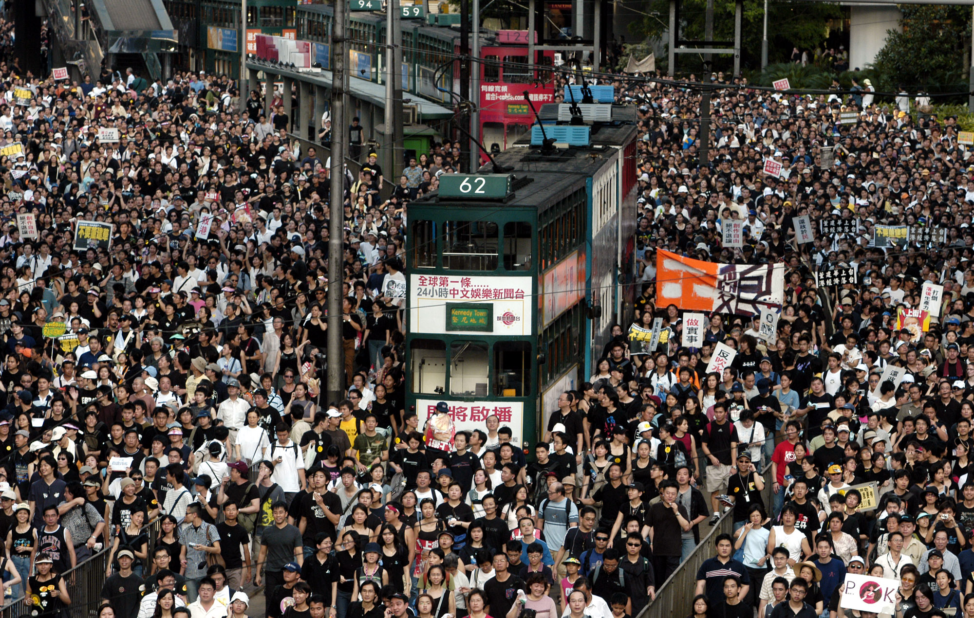 Tens of thousands of people pack a Hong Kong street while marching to Hong Kong government headquarters on July 1, 2003. (Vincent Yu—AP)