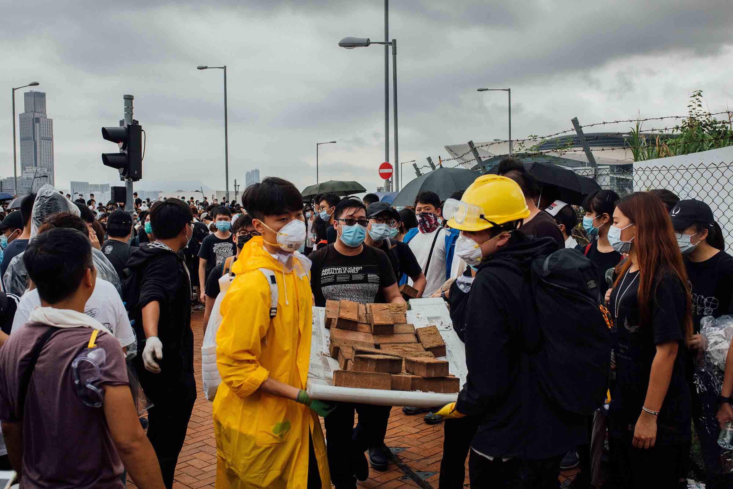 Demonstrators transport bricks at a protest site on June 12. Police said some protesters threw bricks at officers. (Lucien Lung—Riva Press/Redux)