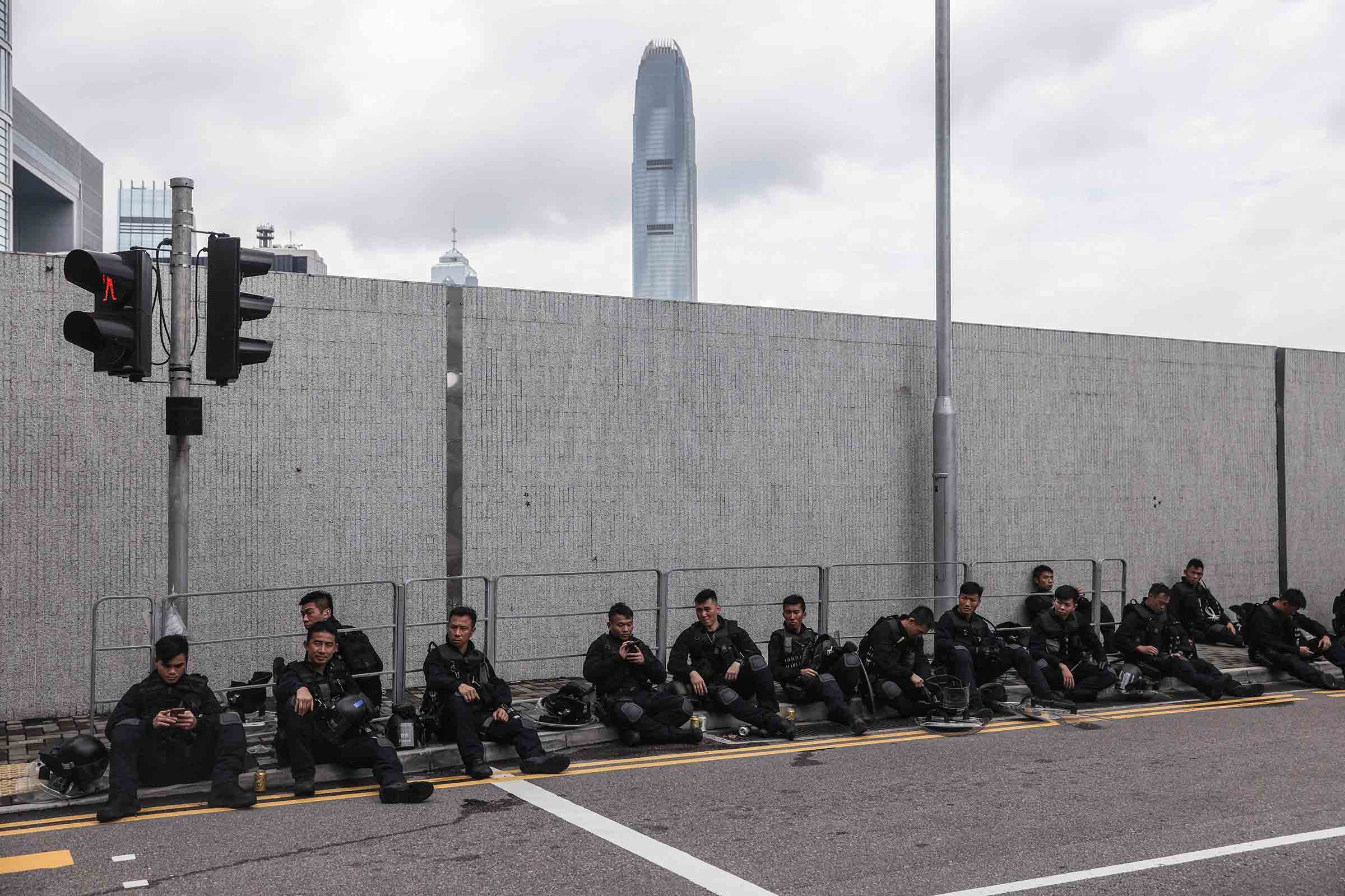 Police rest on a street during a rally near the government headquarters on June 12. (Dale De La Rey—AFP/Getty Images)