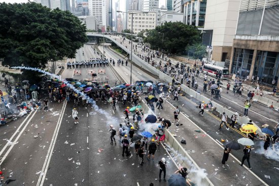 Protesters throw back a tear gas canister fired by police during a rally against an extradition law proposal outside the government headquarters in Hong Kong on June 12.