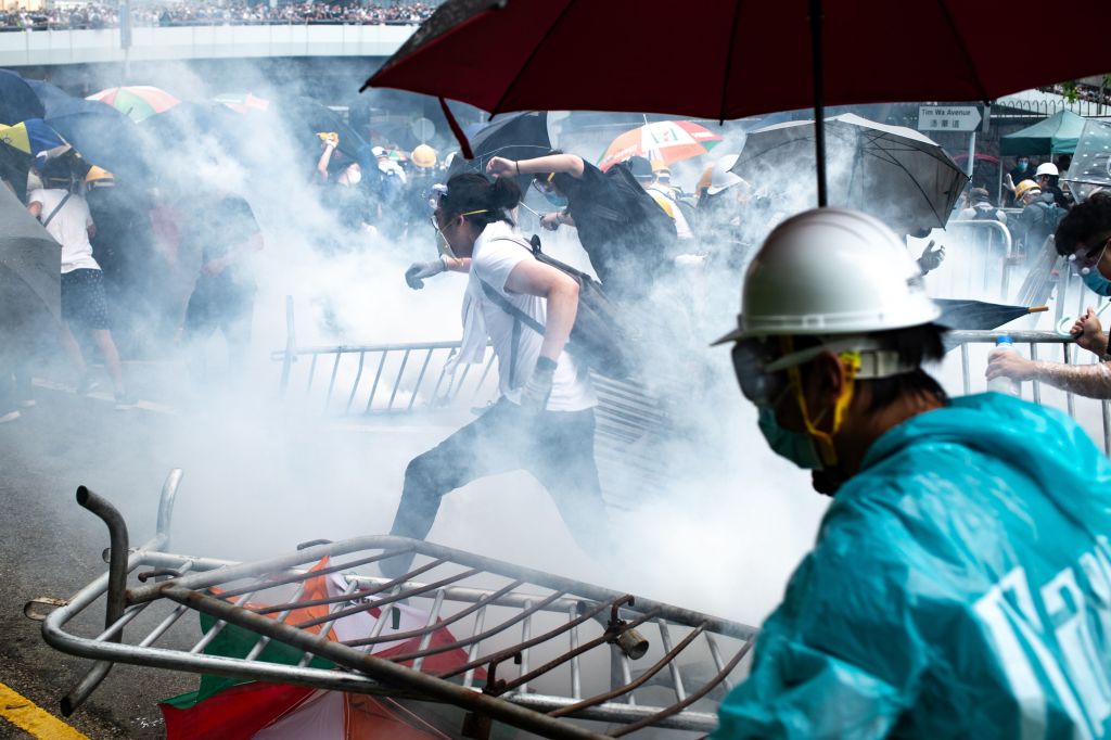 Protesters run after police fired tear gas during a rally against a controversial extradition law proposal outside the government headquarters in Hong Kong on June 12, 2019. (Philip Fong—AFP/Getty Images)