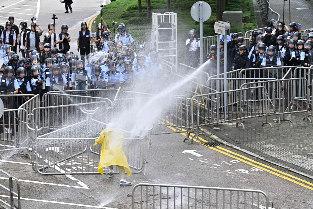 Police officers use a water canon on a lone protestor near the government headquarters in Hong Kong on June 12, 2019. (Anthony Wallace—AFP/Getty Images)
