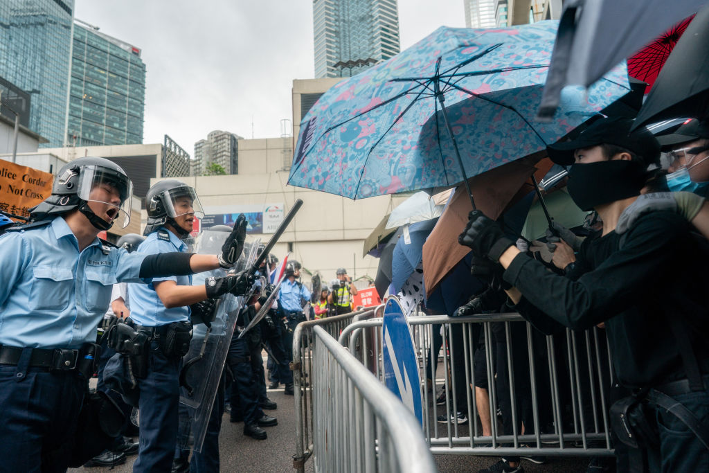 Police officers stand guard as protesters block a street near the government headquarters during a rally against the extradition bill on June 12, 2019. (Anthony Kwan—Getty Images)