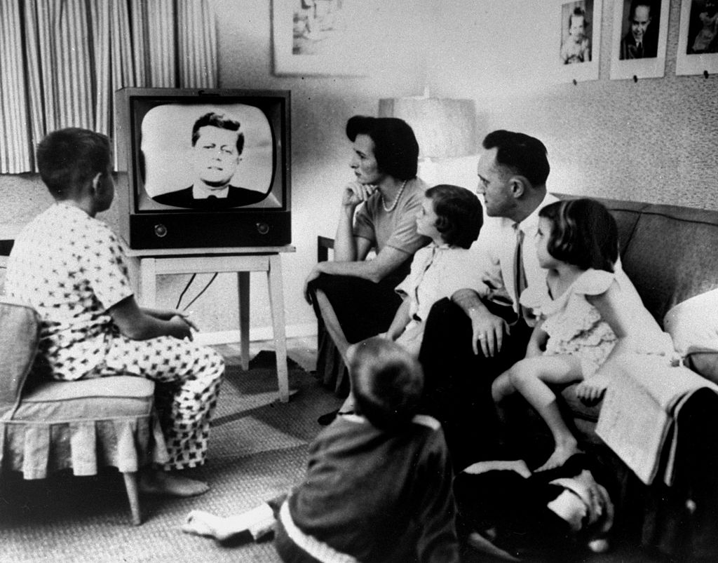 Typical American family gathered around TV, which displays John F. Kennedy's face, to watch debate between Kennedy & Richard Nixon during presidential election. (Time Life Pictures—The LIFE Picture Collection via)