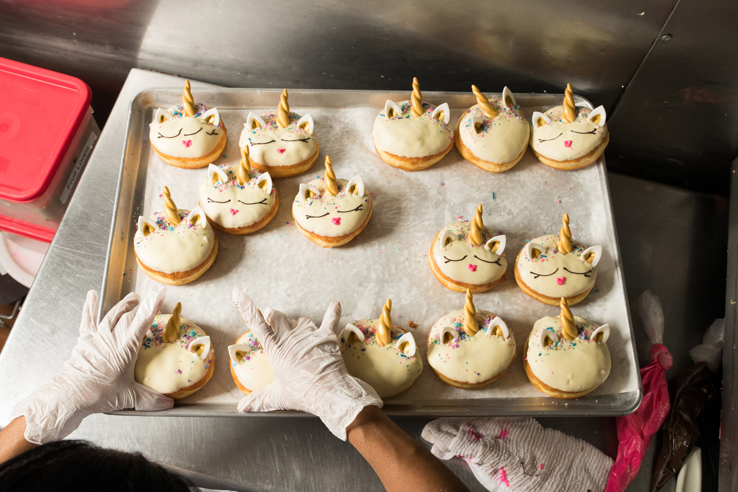 Maria Reyes decorates unicorn doughnuts at California Donuts in Los Angeles on June 6, 2019. (Theo Stroomer for TIME)