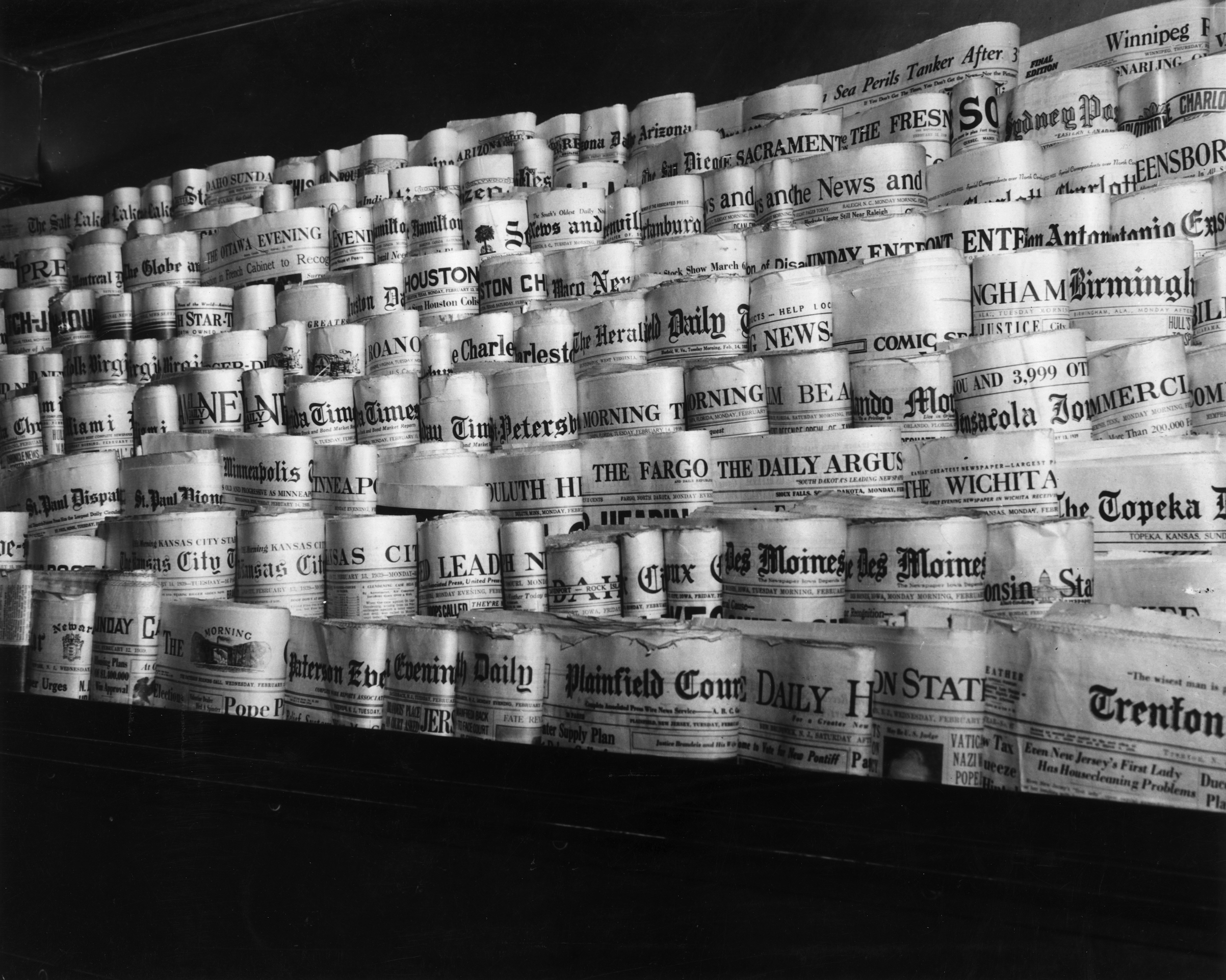 February 1939:  View of rows of newspapers from various American cities sitting in the racks of a newsstand, Times Square, New York City. (Hulton Archive/Getty Images)