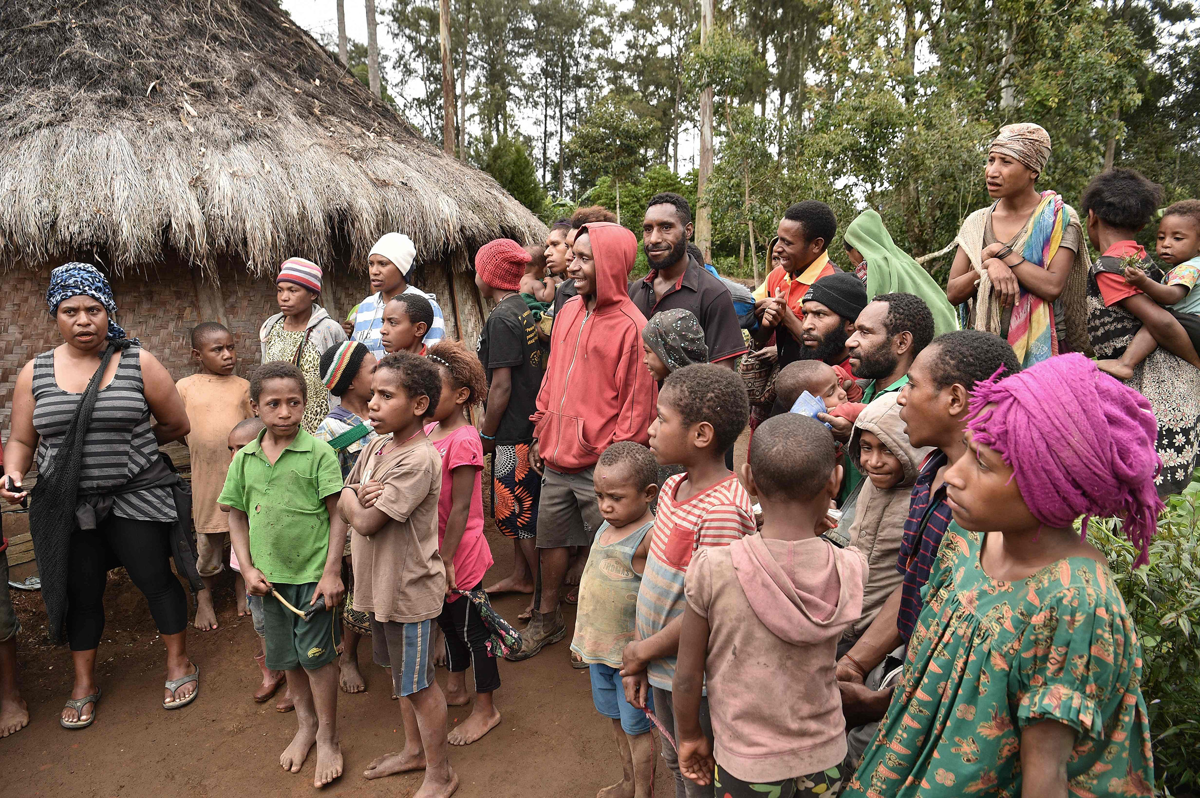 Neighbors gather near the home of 55-year-old mother-of-two Rachel in the Tsak Vally in the Highlands of Papua New Guinea after she recounts how in April 2017, she was accused of sorcery and tortured by people she knew, on November 20, 2018. (Peter Parks—AFP/Getty Images)