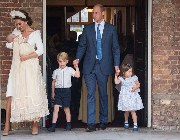 Princess Charlotte of Cambridge and Prince George of Cambridge hold hands with their father, Prince William, Duke of Cambridge, as Prince Louis of Cambridge is carried by his mother, Catherine, Duchess of Cambridge after his christening service at the Chapel Royal, St James's Palace, London on July 9, 2018. (Dominic Lipinski—Getty Images)