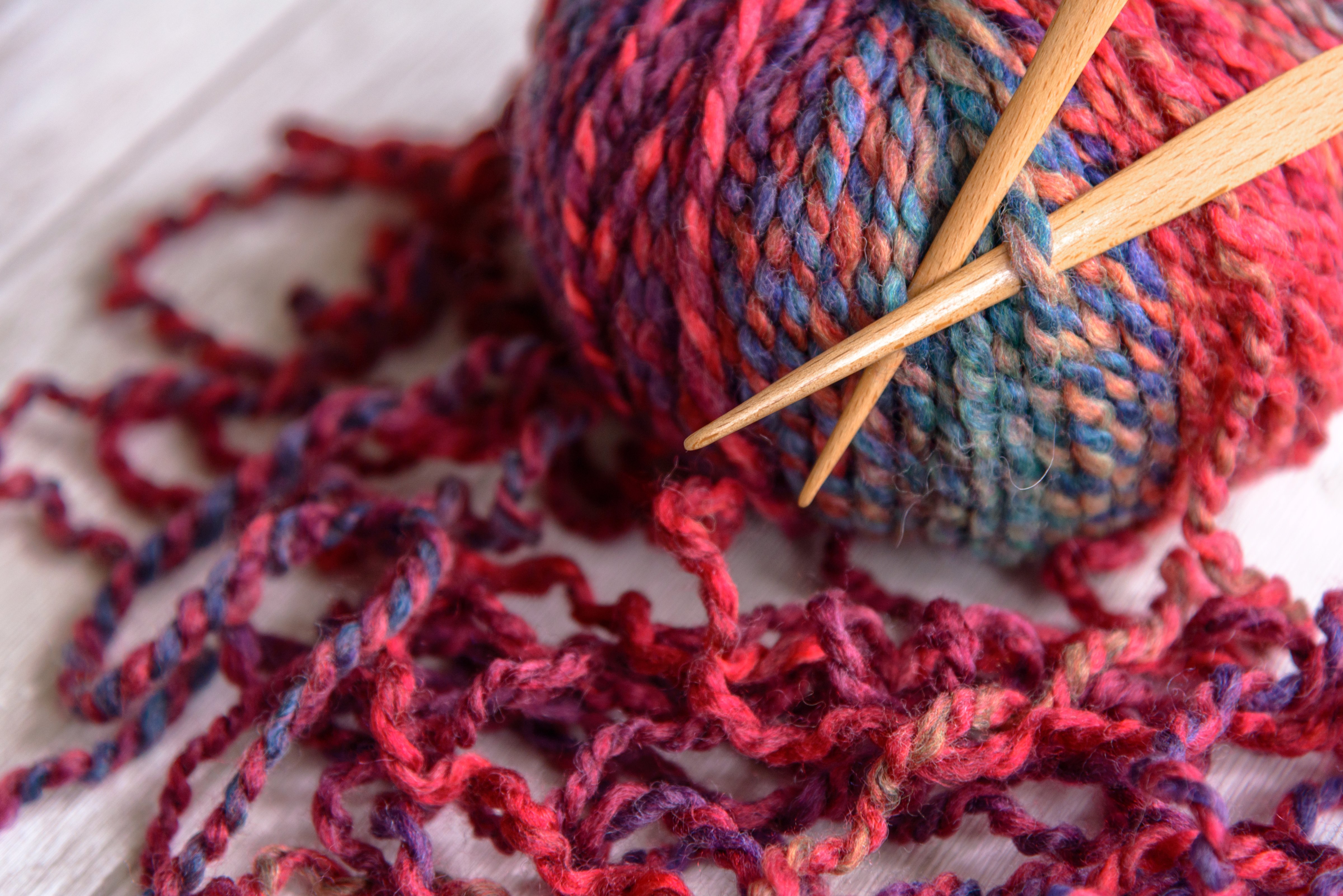 ball of purple yarn and knitting needles