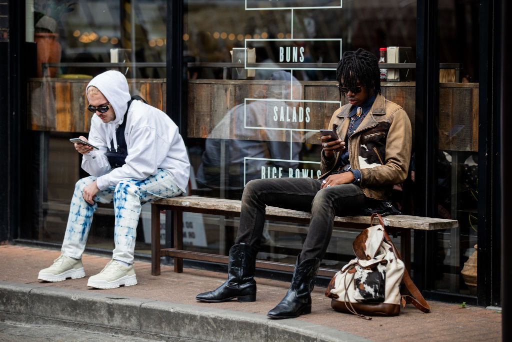 Guests sitting on a bench texting seen outside Iceberg during London Fashion Week Men's June 2019 on June 08, 2019 in London, England. (Christian Vierig&mdash;Getty Images)